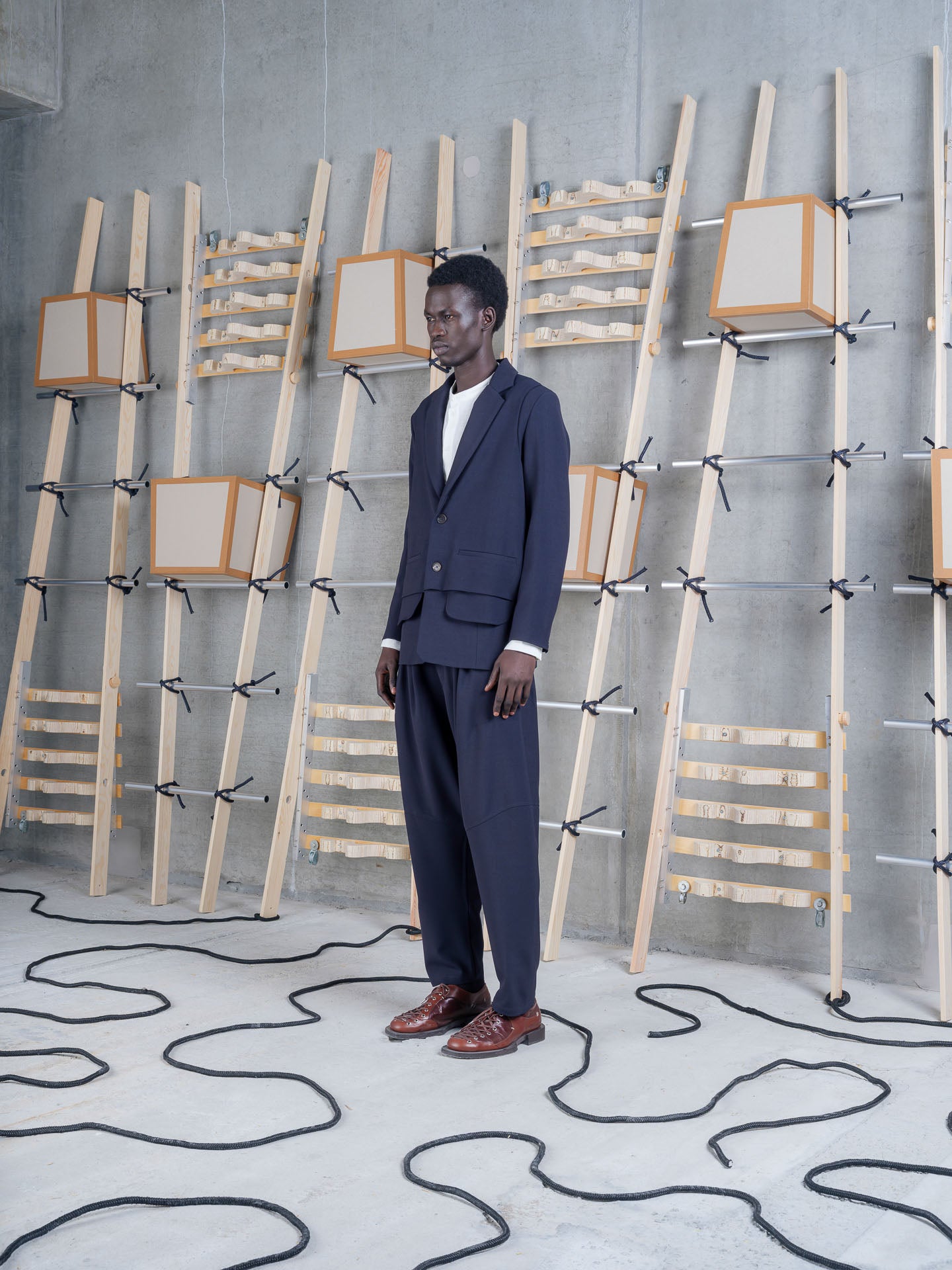 Side view of Henrik Vibskov Ants Blazer in Dark Navy styled as part of a tailored suit.