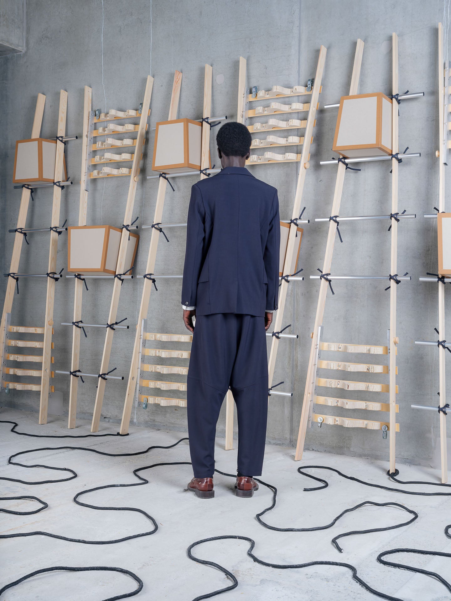 Back view of Henrik Vibskov Ants Blazer in Dark Navy worn with matching trousers.
