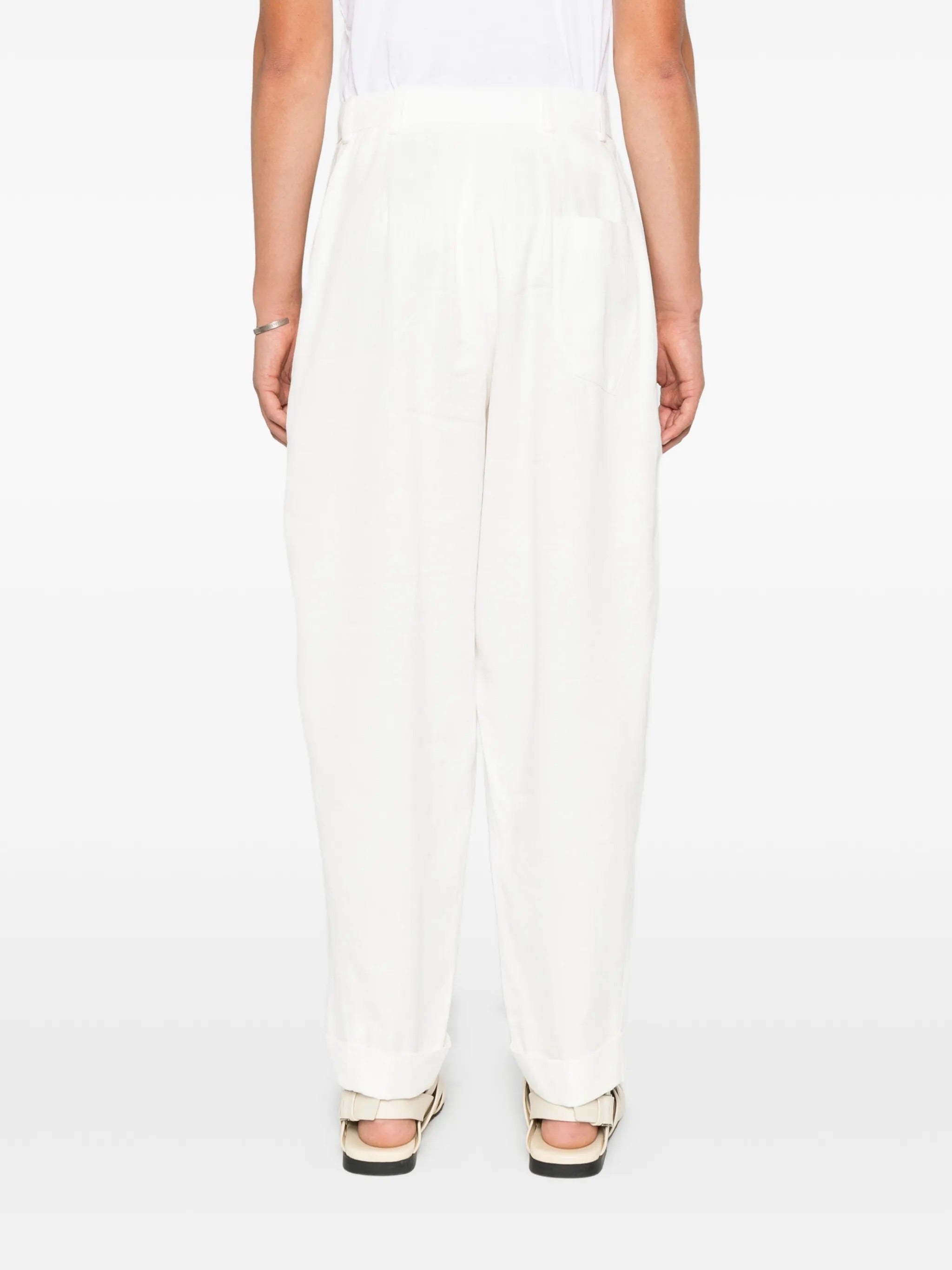 House Of The Very Islands Blake Trousers in Off White - side view on model showing relaxed silhouette and turn-up hems
