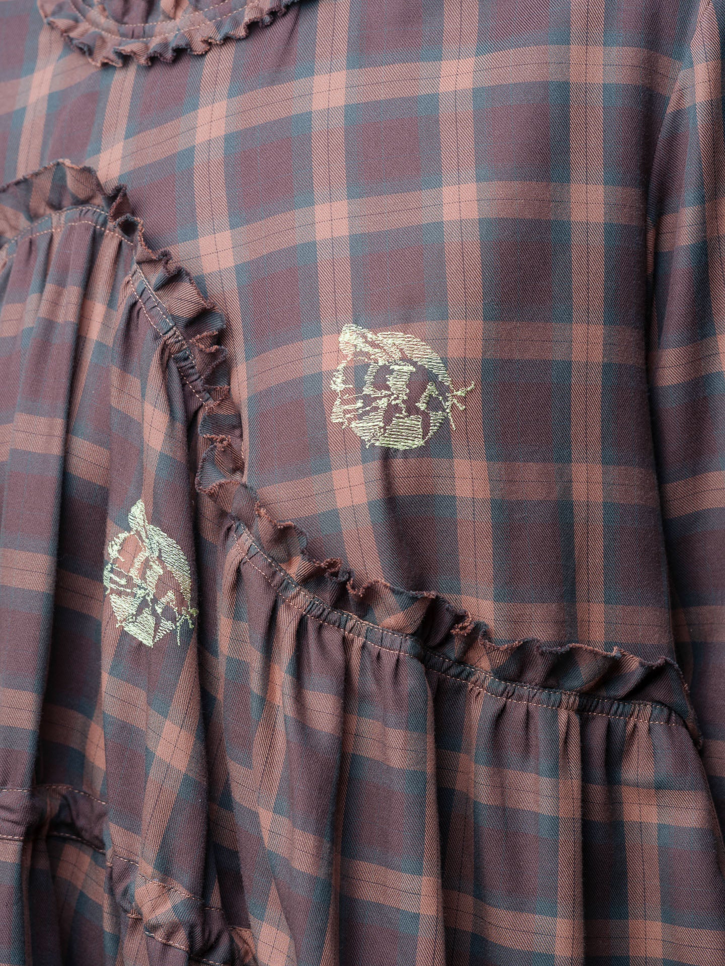 Close-up of Henrik Vibskov Bon Chalant Dress LS in Brown Cotton Checks highlighting the embroidered floral details and gathered waist seam.