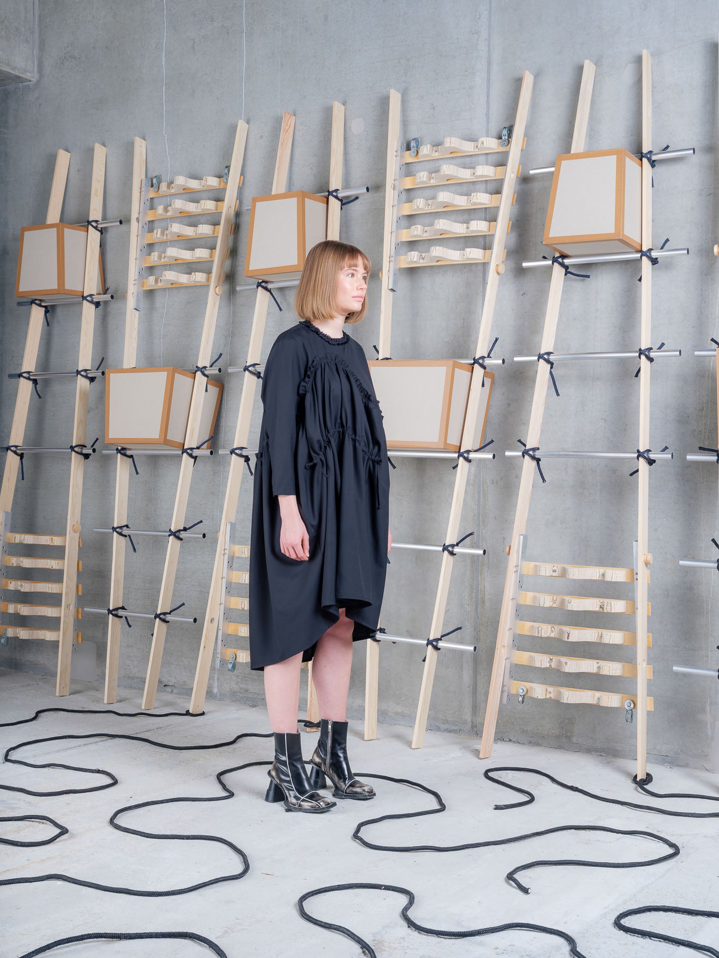 Model wearing Henrik Vibskov Bon Chalant Dress LS in Black rear three-quarter view