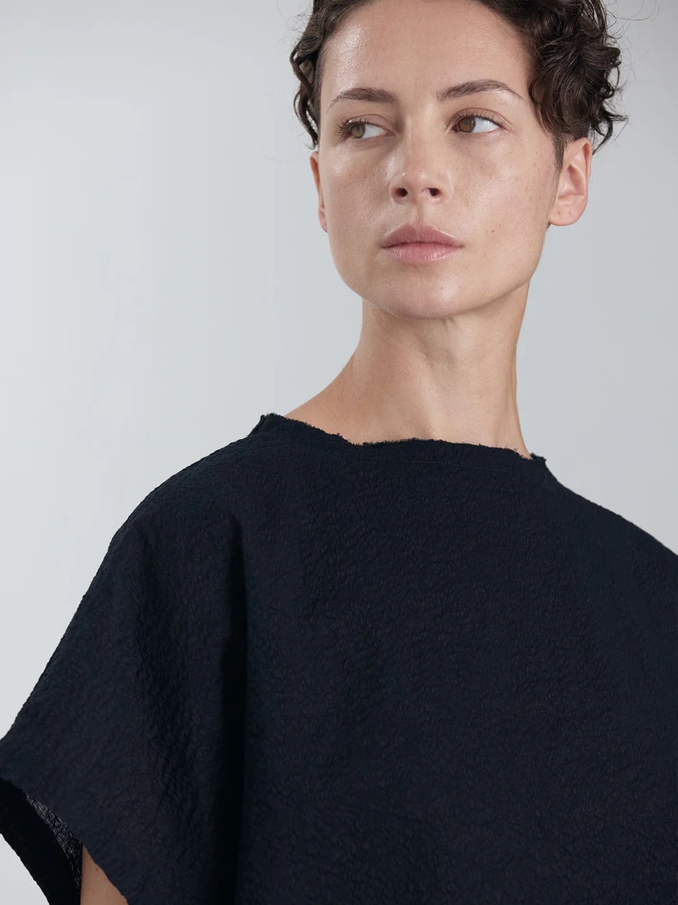 Black Crane Boxed Top in Midnight - close portrait view on model showing raw edge frayed crew neck detail