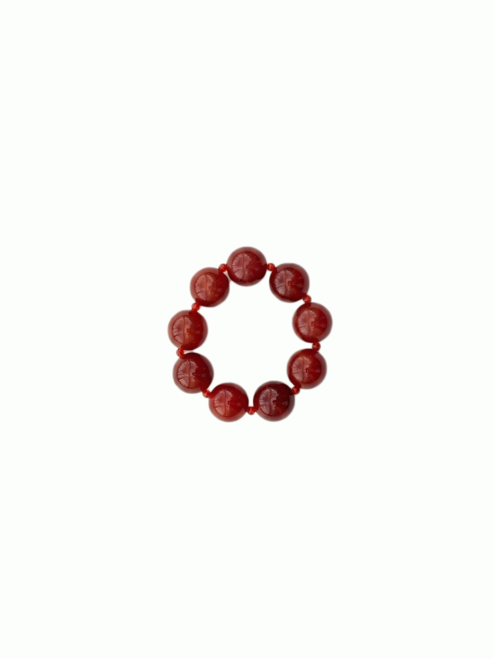 Round, natural red agate bracelet from De Silang on a white background