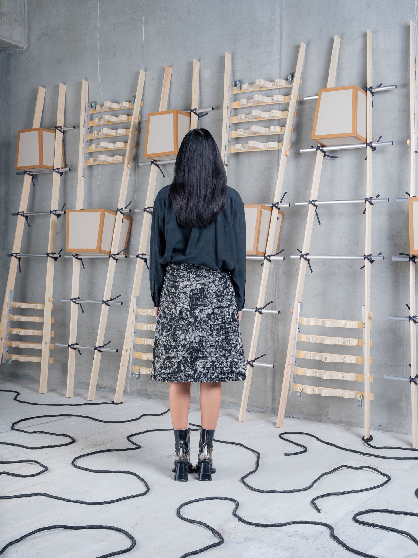 Back view of Henrik Vibskov Double Ki Shirt in Black worn with a patterned skirt, showcasing the relaxed fit.