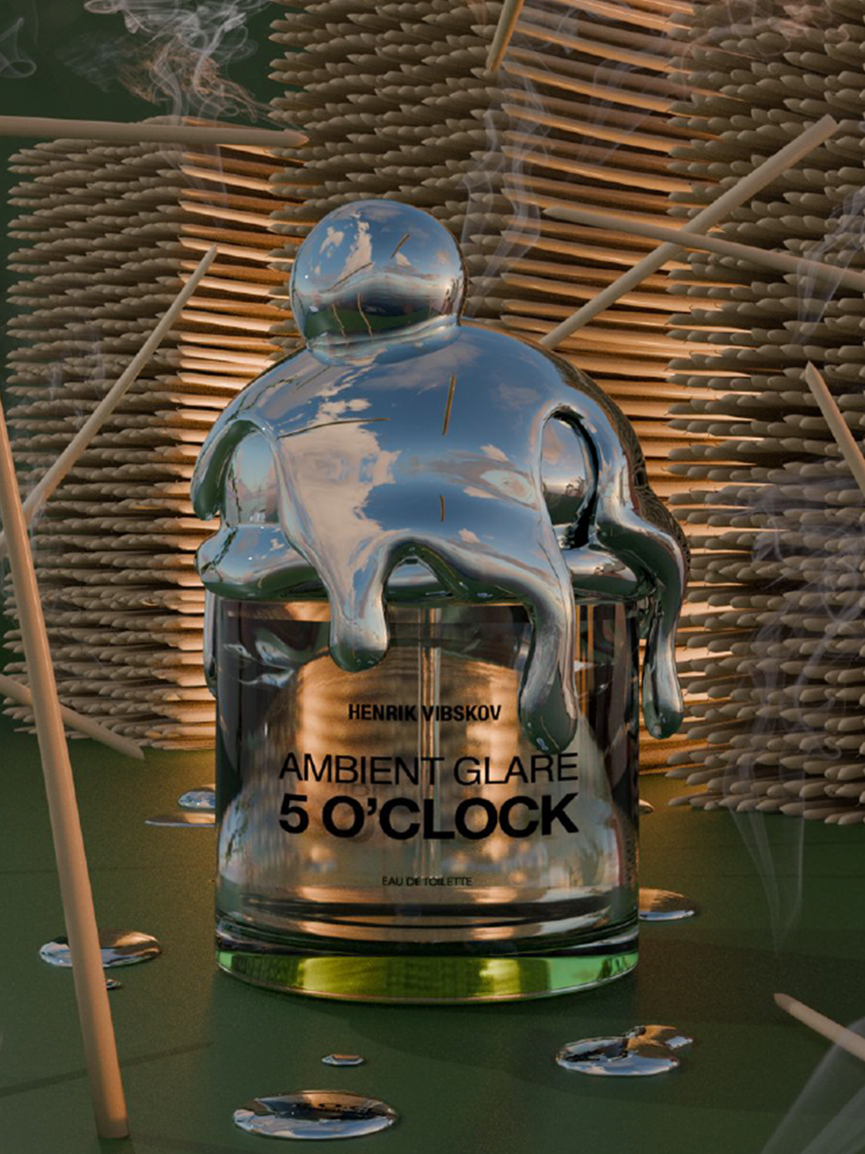 Glass perfume bottle from Henrik Vibskov with a silver lid with a reflective surface on a textured background
