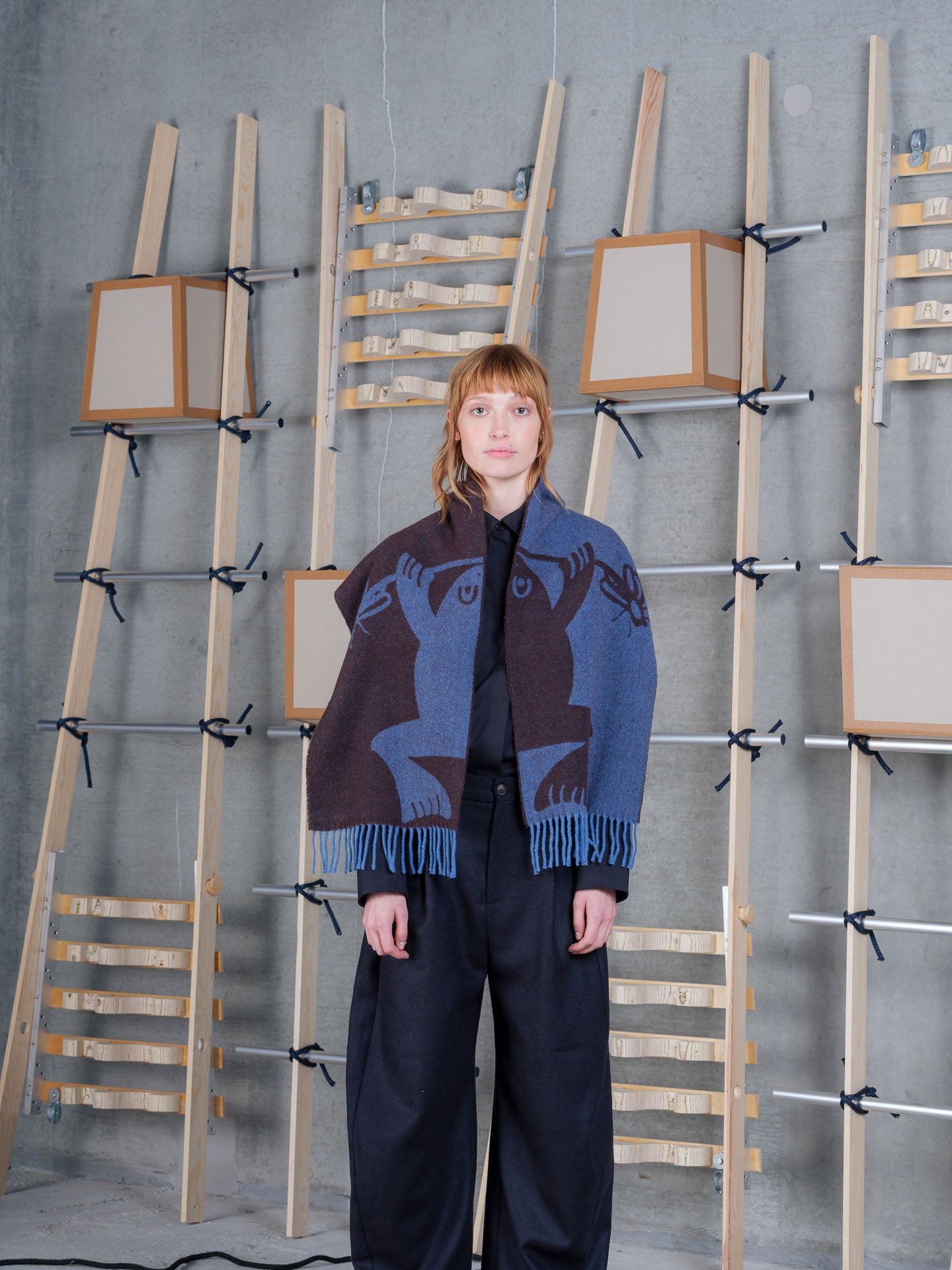 Henrik Vibskov Bug Press Scarf Blue Bug Brown, model front view, scarf draped over shoulders with black trousers