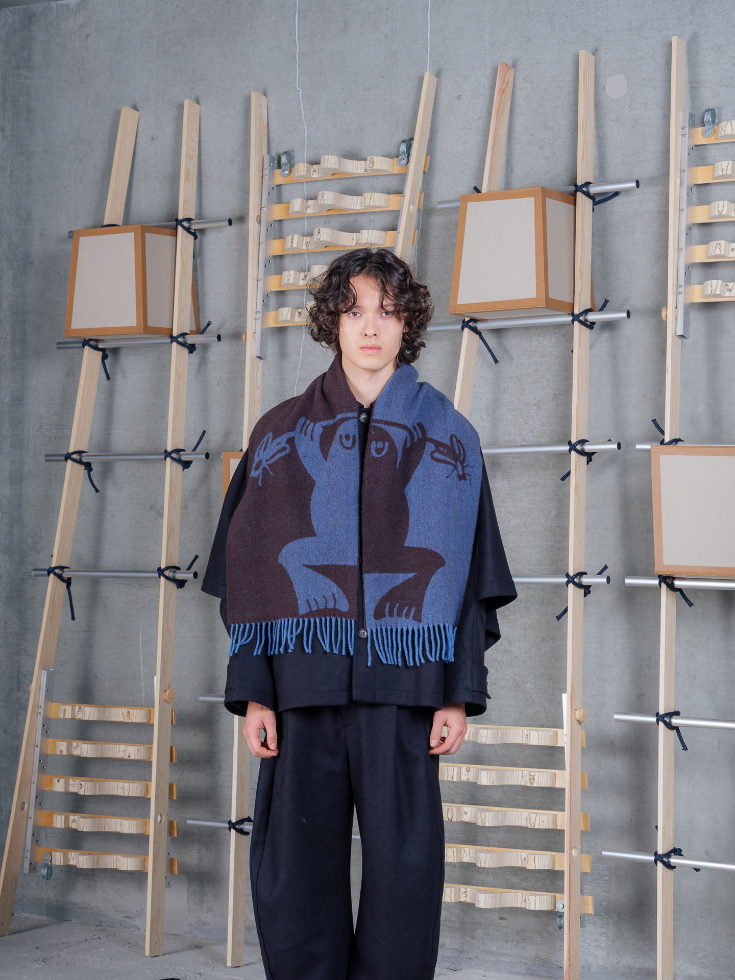 Henrik Vibskov Bug Press Scarf Blue Bug Brown, model front view, scarf worn open over black jacket