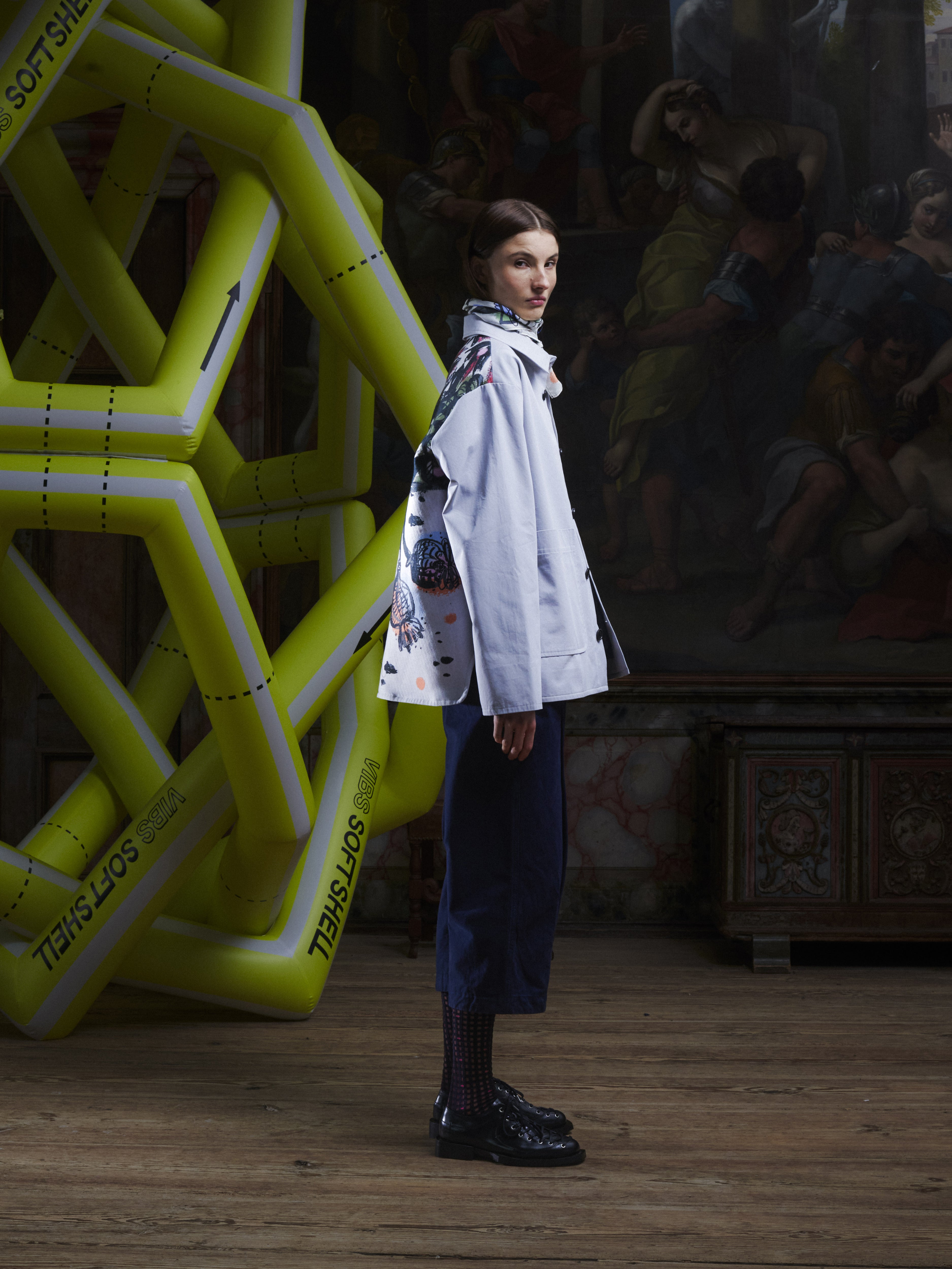 Side view of the female model wearing the Care Jacket in Carrots from Henrik Vibskov Spring/Summer 2026 Studio Collection, showing the jacket’s colourful carrot print, profile shape, and straight hem.