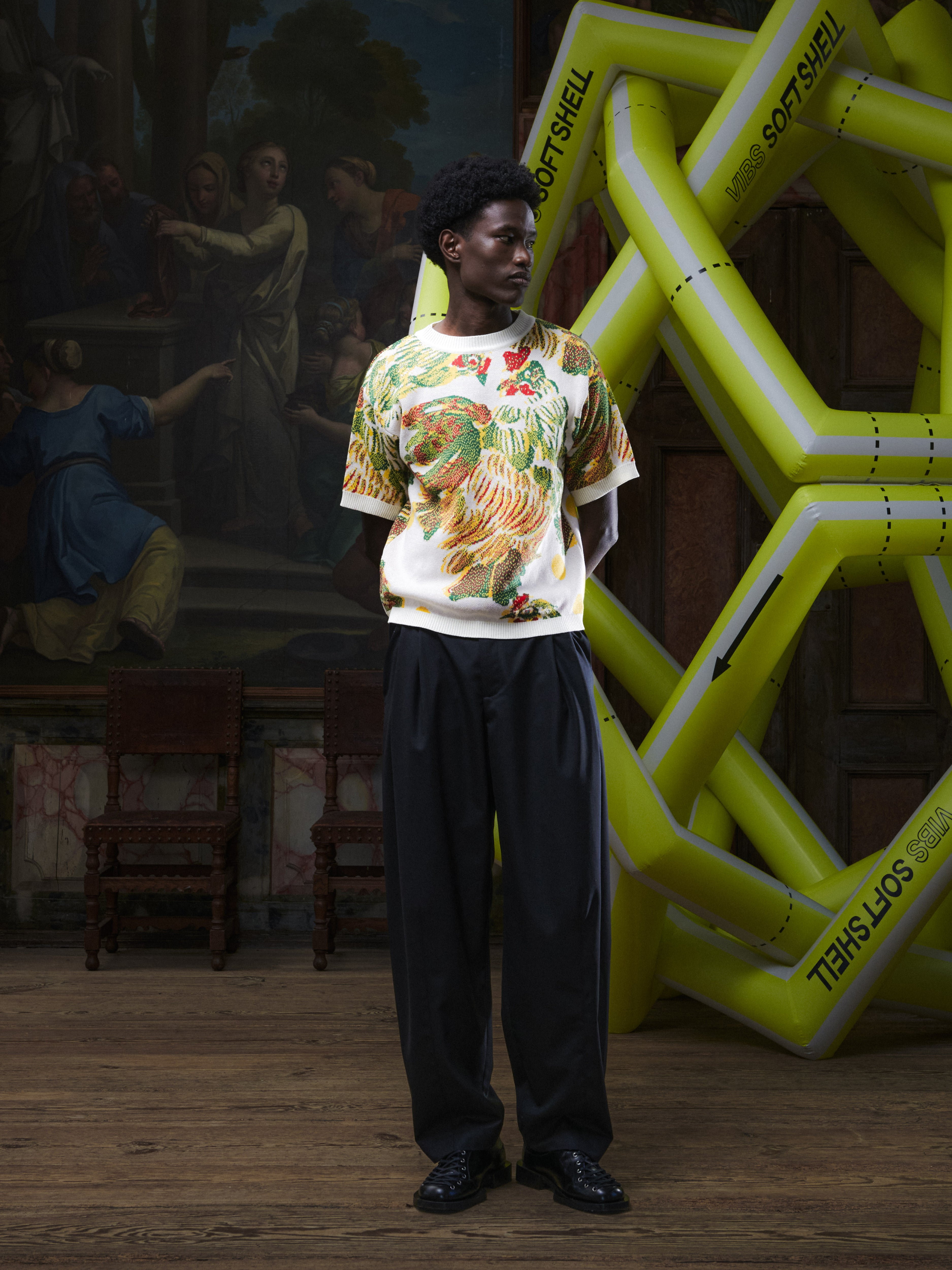 Front full-body view of the male model wearing the Chicken T Knit in Chicken Ecru from Henrik Vibskov Spring/Summer 2026 Studio Collection, showing the crew neck, short sleeves, and unisex relaxed fit.