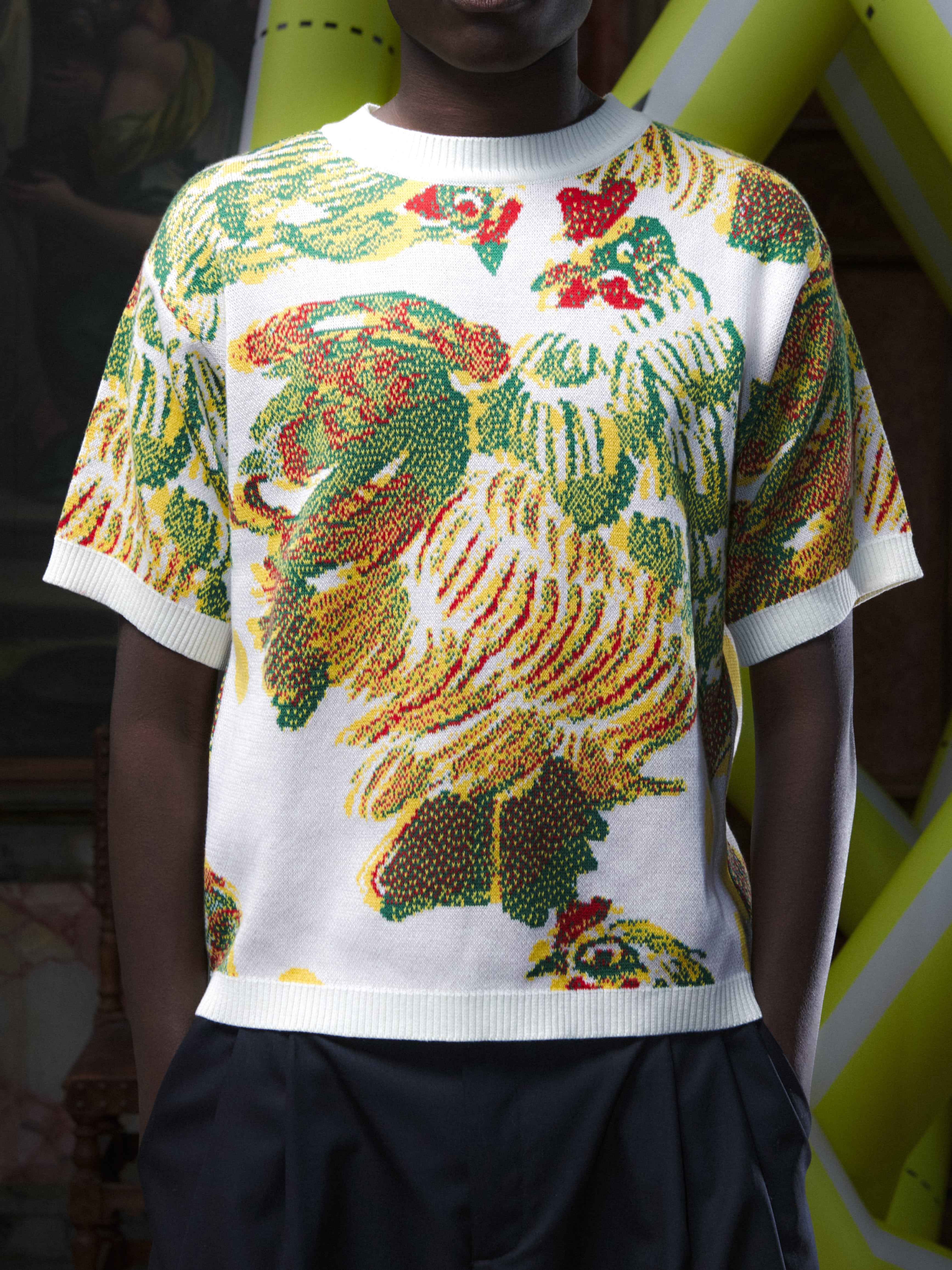 Close-up of the male model wearing the Chicken T Knit in Chicken Ecru from Henrik Vibskov Spring/Summer 2026 Studio Collection, focusing on the chicken motif, knit texture, and crew neckline.