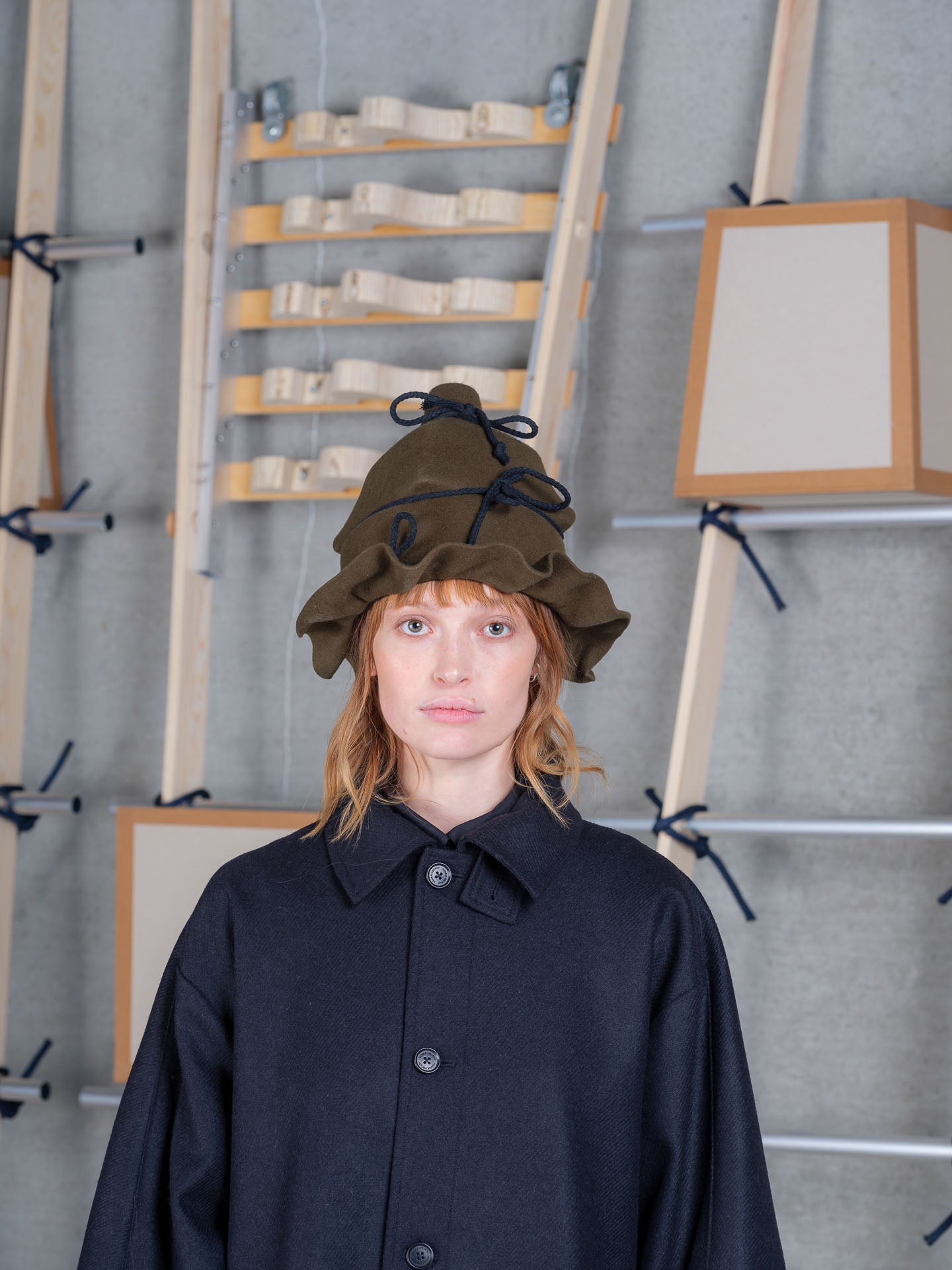 Henrik Vibskov moss green wool wrap hat with sculptural crown, irregular brim and handmade rope tie detailing