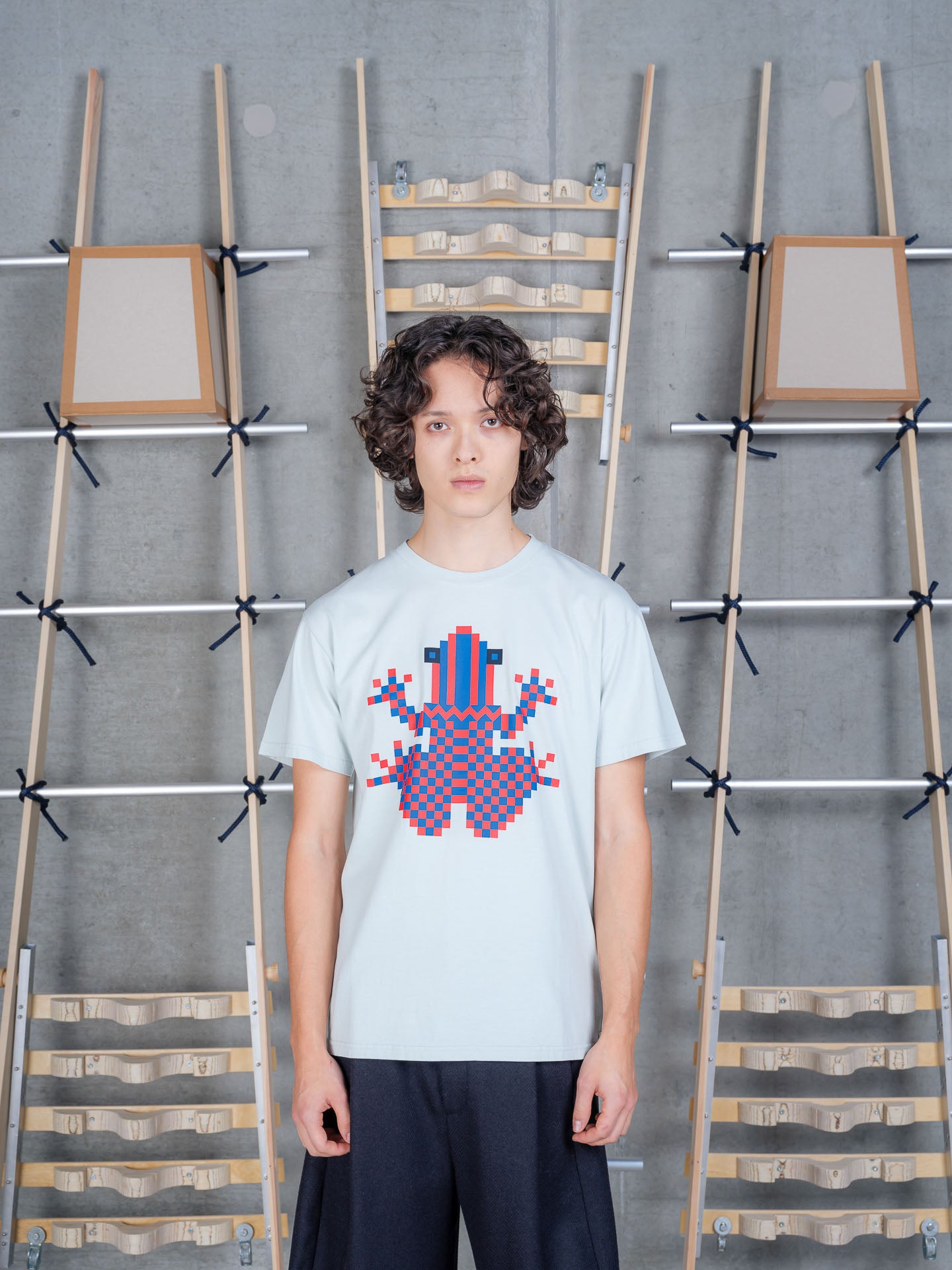 Henrik Vibskov Cross Stitch Tee in Sky Grey worn on model, front view, bold pixelated frog graphic, crew neck, short sleeves, relaxed fit