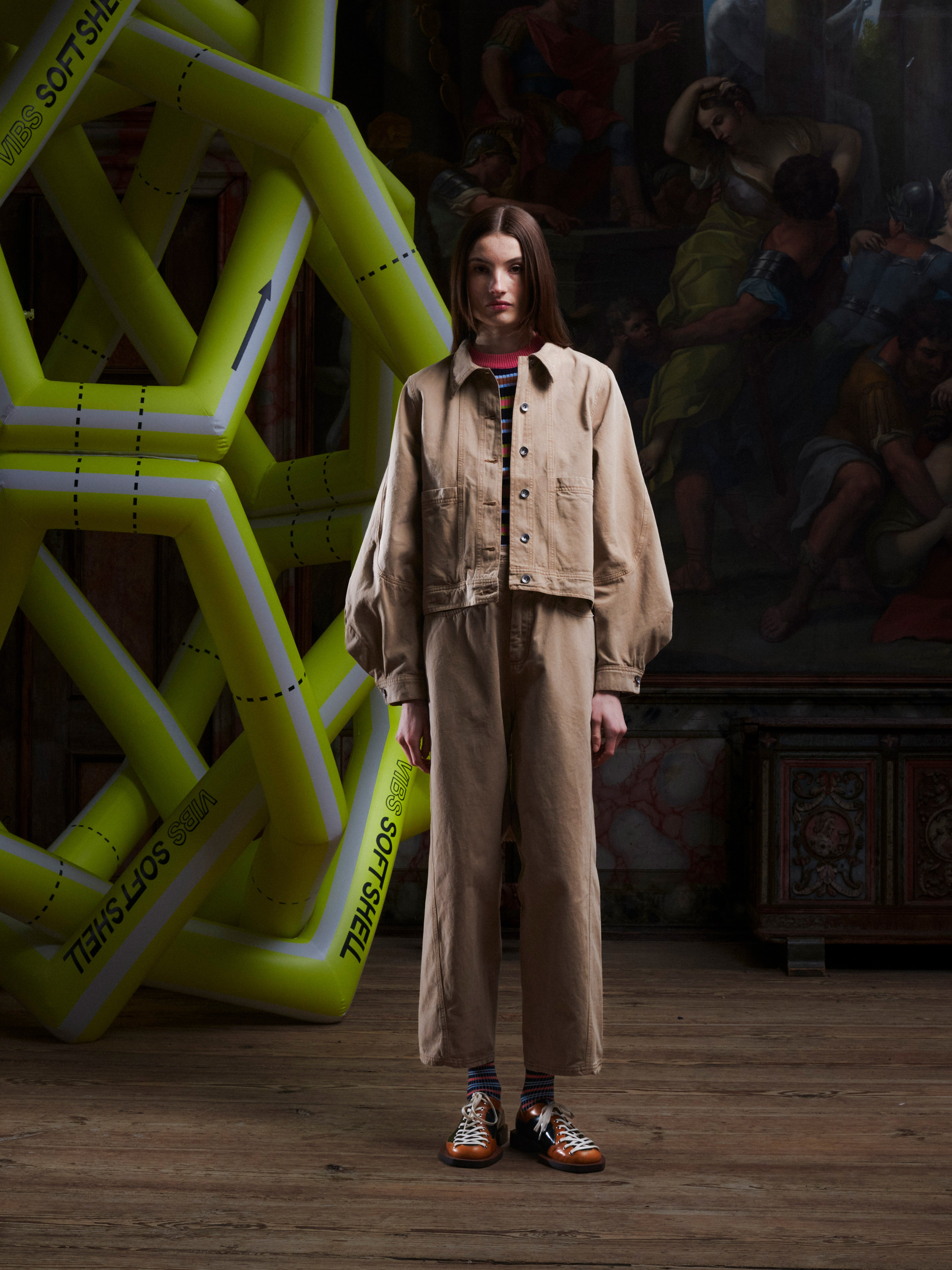 Female model wearing the dark beige Curved Denim Pants from the front, showing the relaxed straight-leg fit in size L. Model is 185cm tall and wears size L.