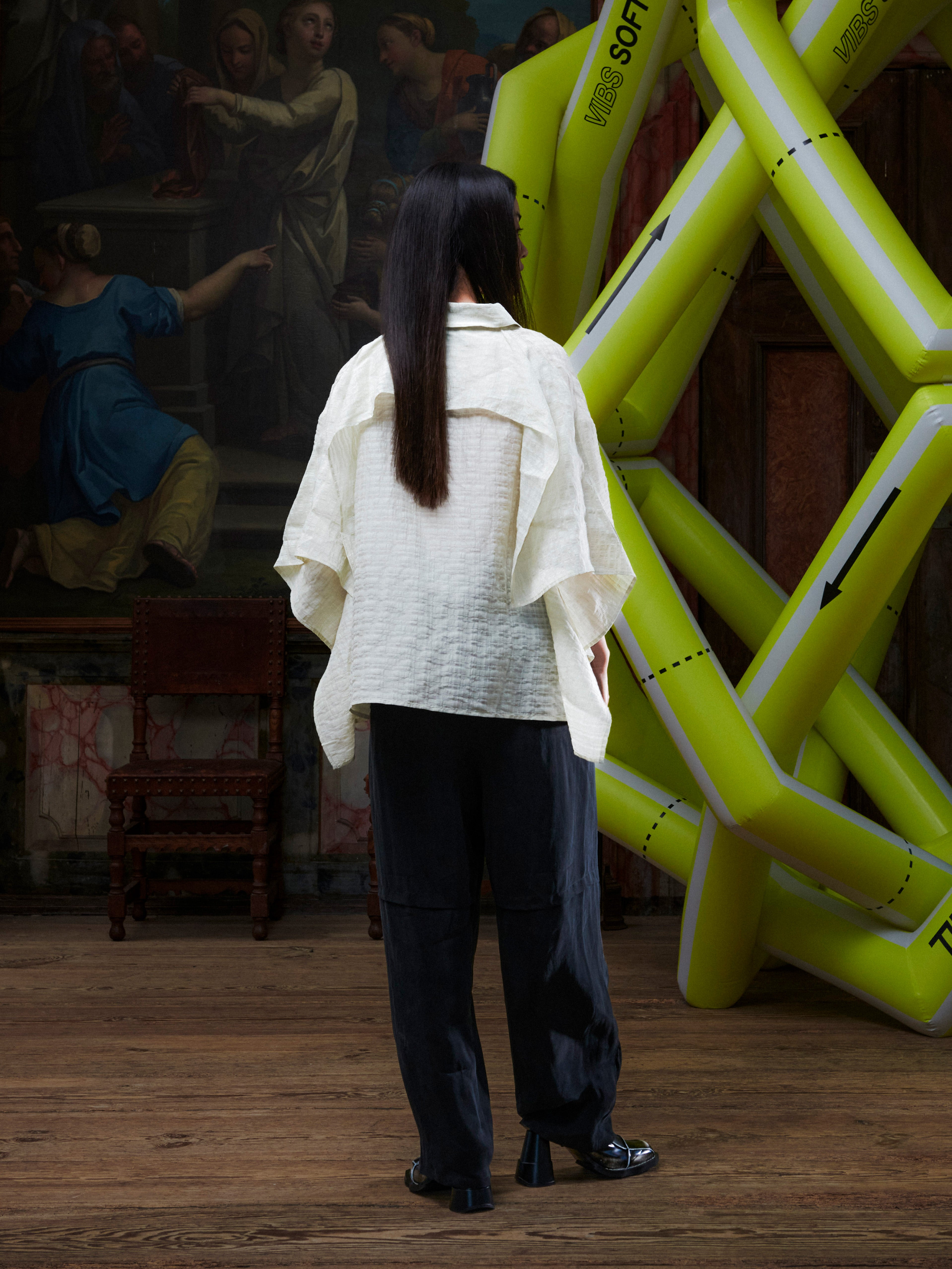 Back view of female model wearing the Drawstring Pants in Black, showing the minimal black design and straight-leg shape.