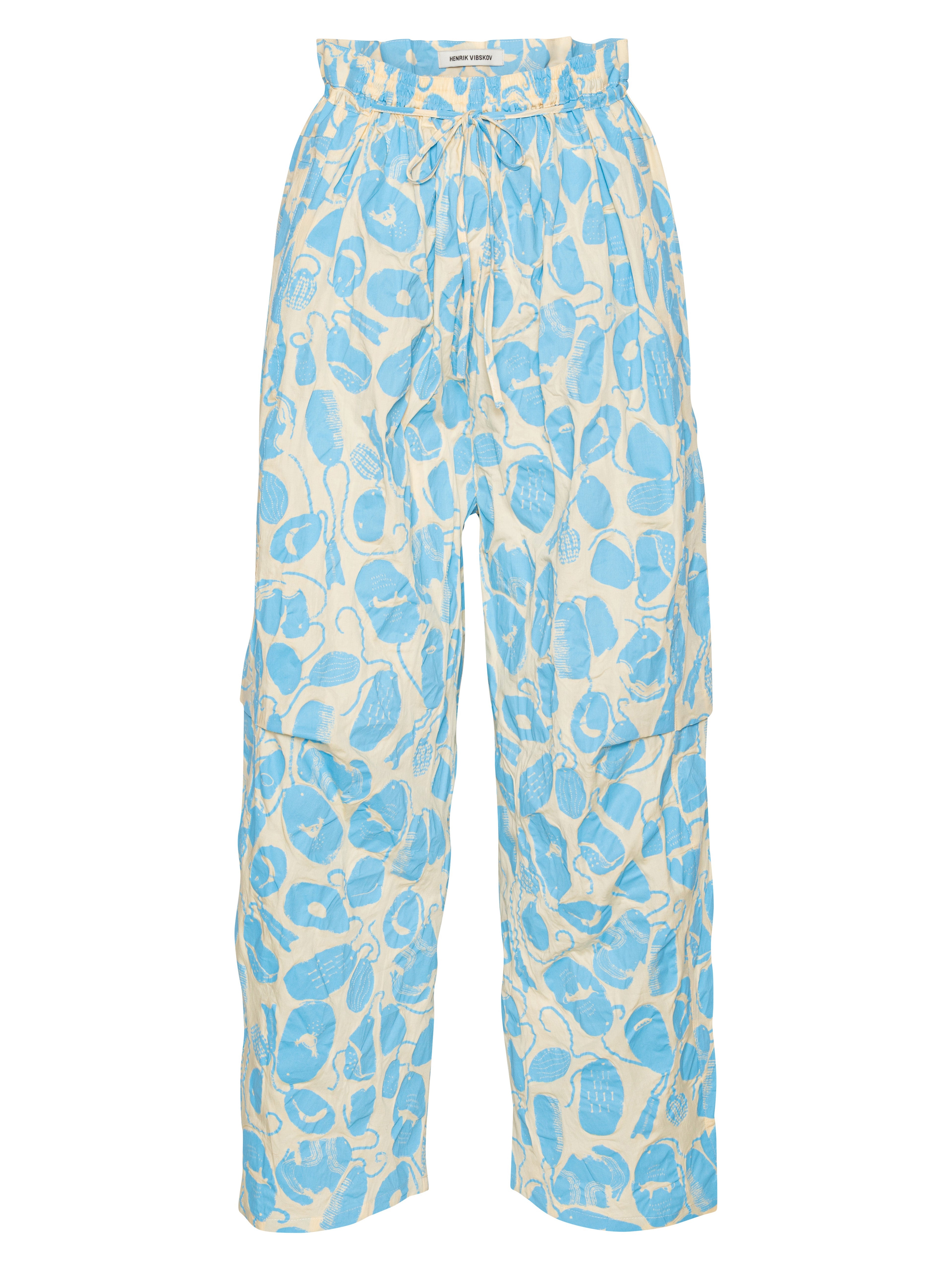 Front view of the Drawstring Pants in Ecru Amulets, showing the off-white fabric with blue amulets pattern, straight legs, and elastic drawstring waistband.
