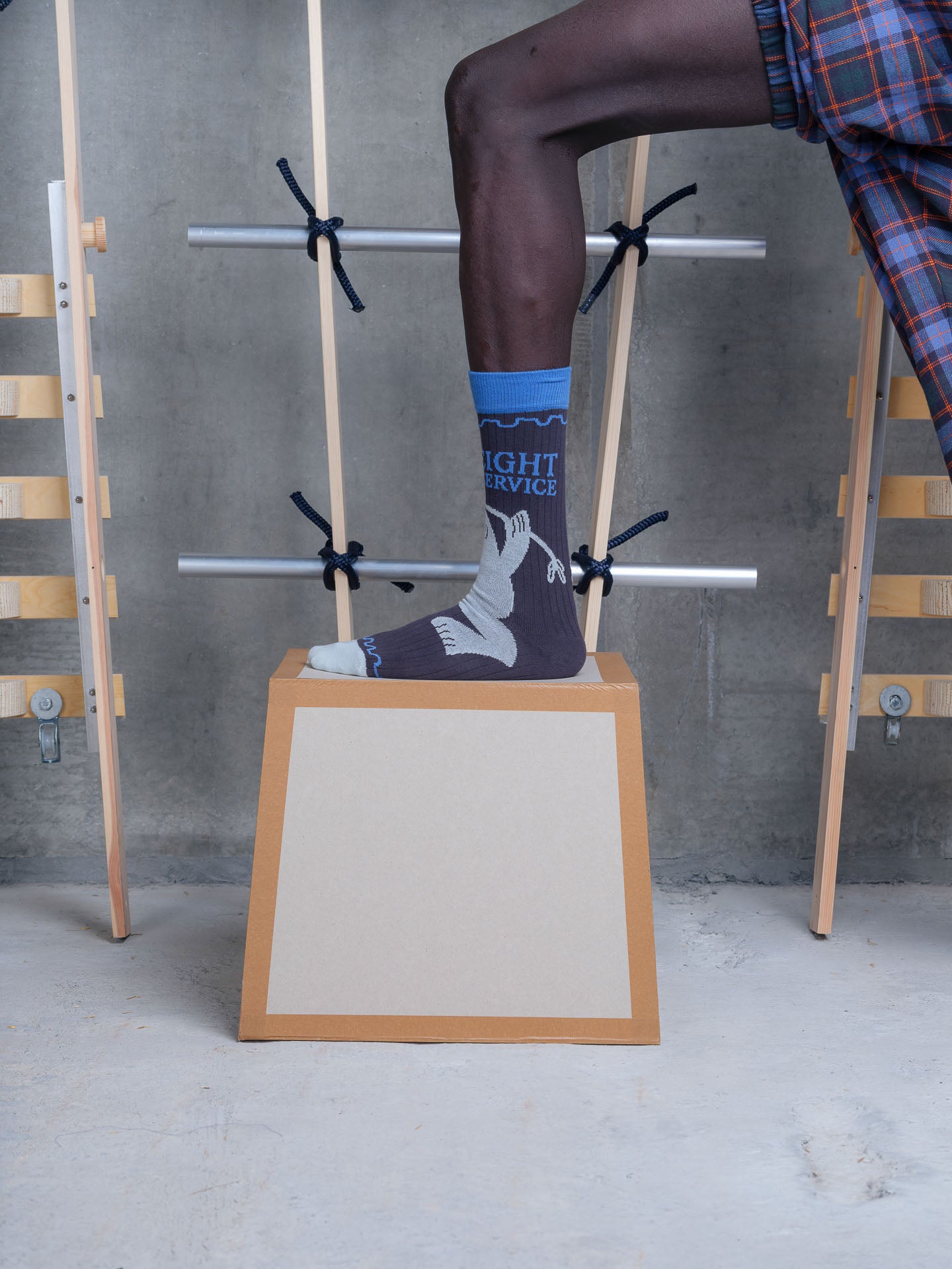 Henrik Vibskov Flyweight Sock Black Postal Grey, worn on foot, styled on display box showing fit and graphic placement