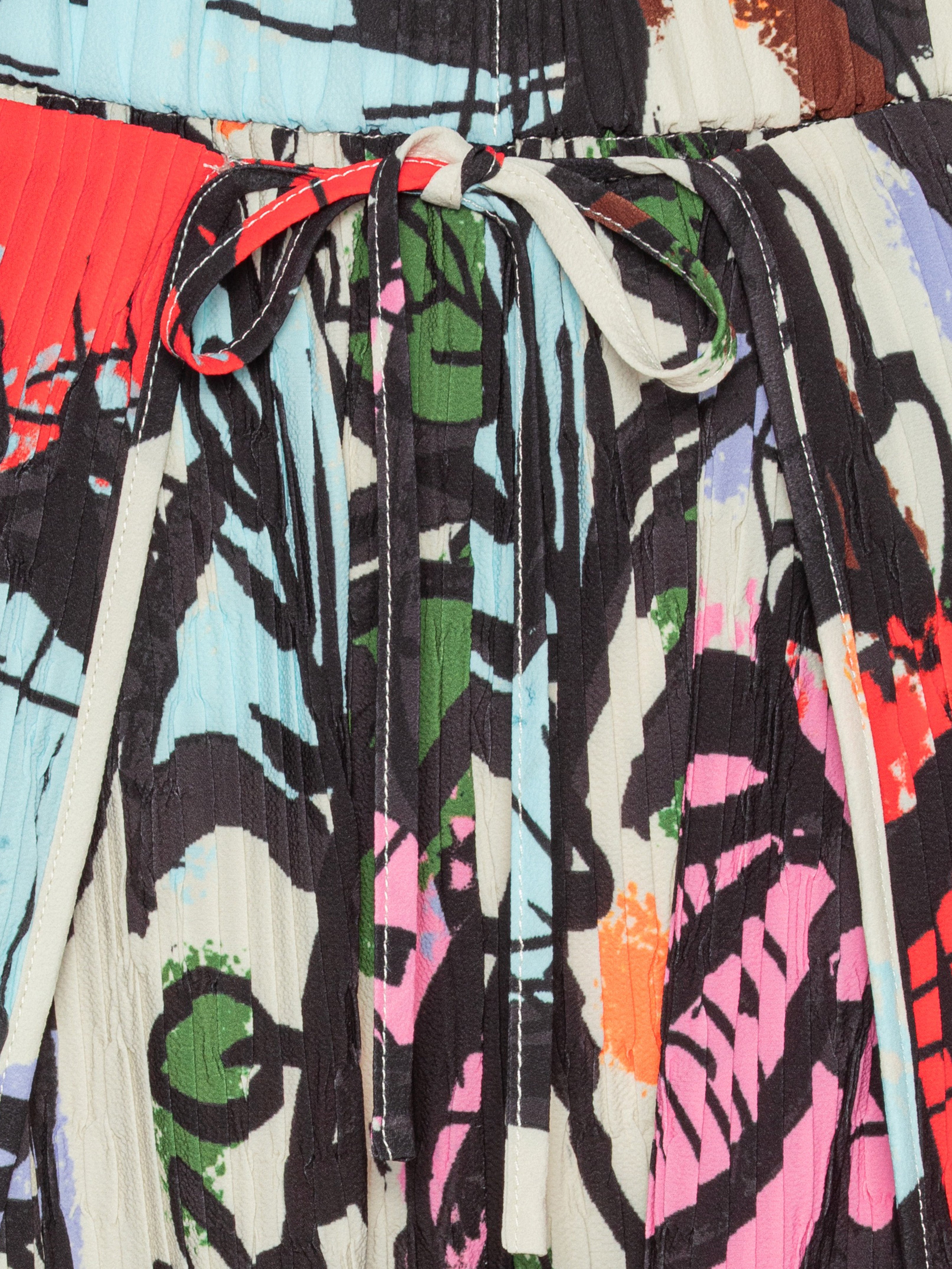 Close-up of the Henrik Vibskov Fold Plissé Pants in Carrots, highlighting the detailed root vegetable illustrations, pleated texture, and elastic drawstring waistband.