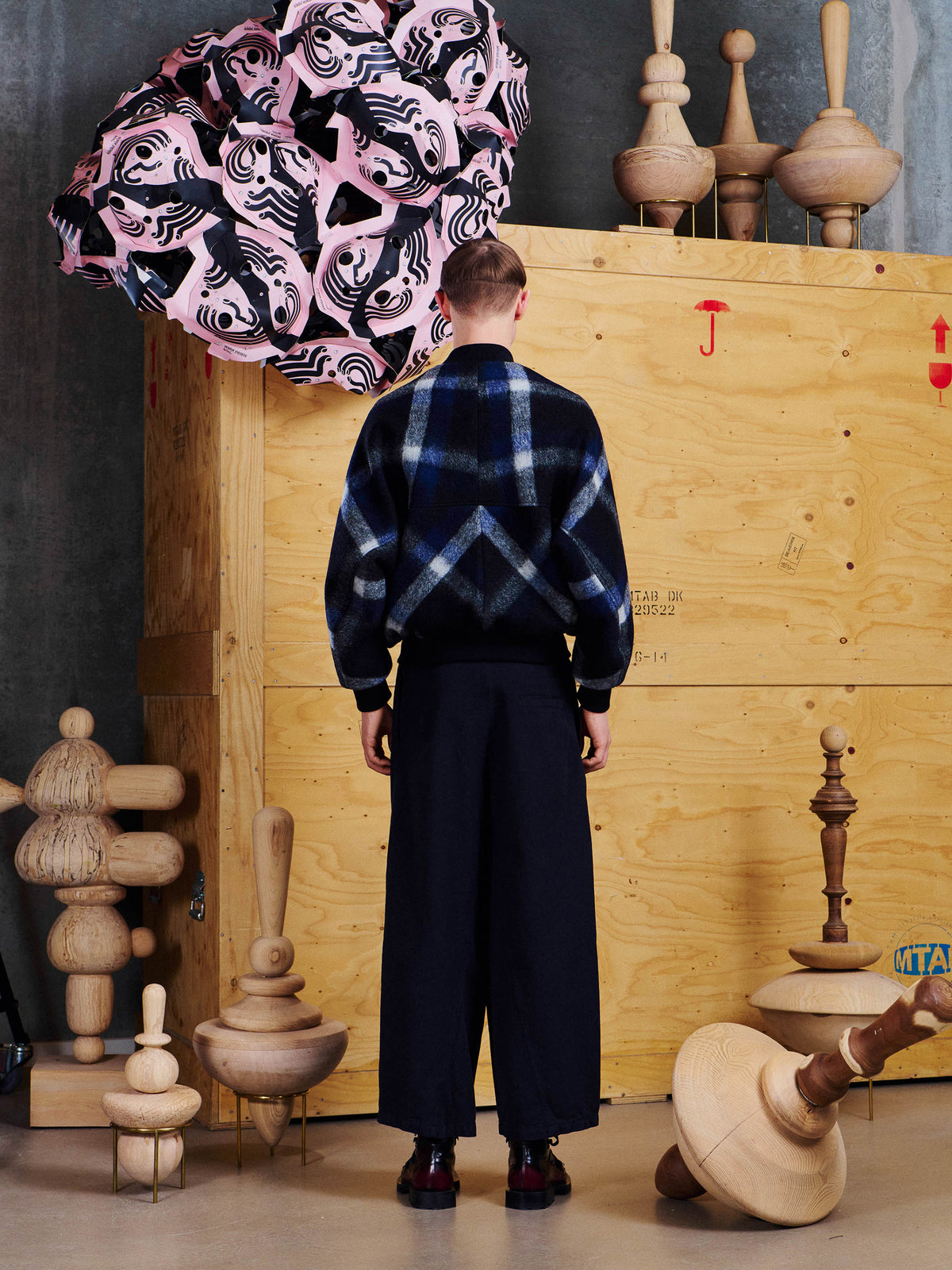 Back view of male model wearing Henrik Vibskov Merry Bomber, showing the oversized check pattern and relaxed silhouette.
