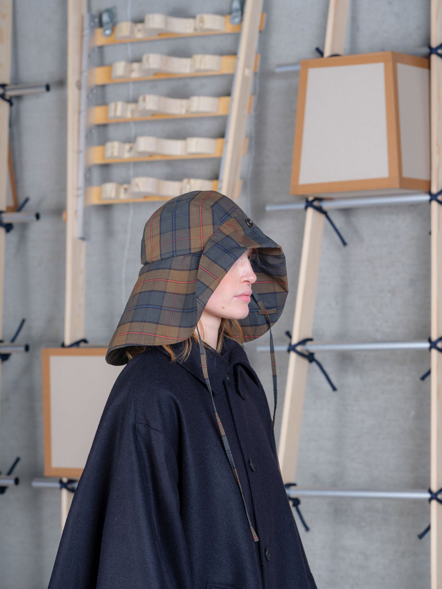 Profile view of Nilsson Fisherman Hat by Henrik Vibskov in tartan with chin tie straps and foldable brim