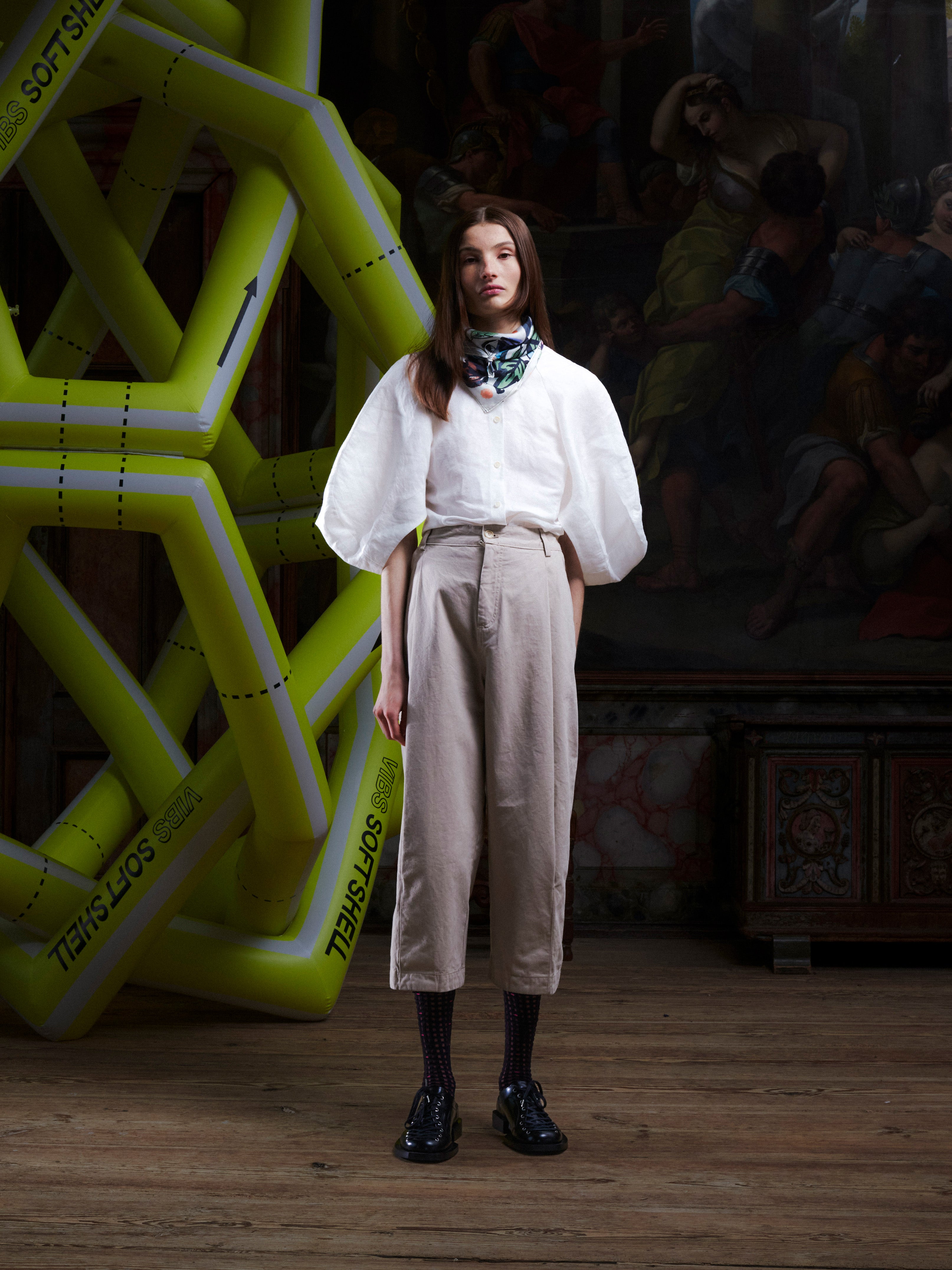 Female model wearing the Henrik Vibskov Open Dart Pants in sand beige, front view. The model is 181 cm and wears size XS, showing the pleated front, wide cropped legs, and relaxed fit.