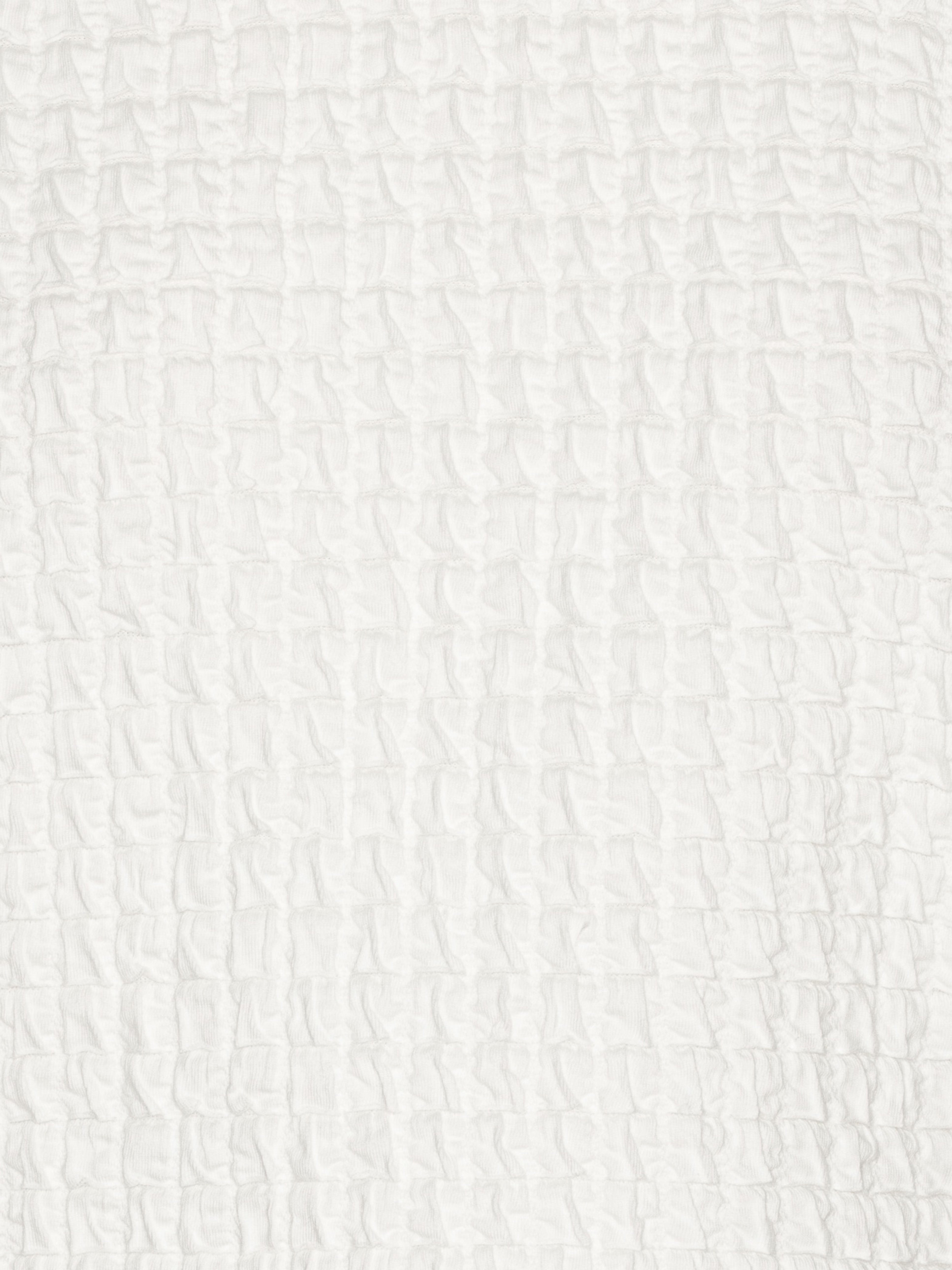 Close-up showing the textured off-white fabric of the Persey Top.