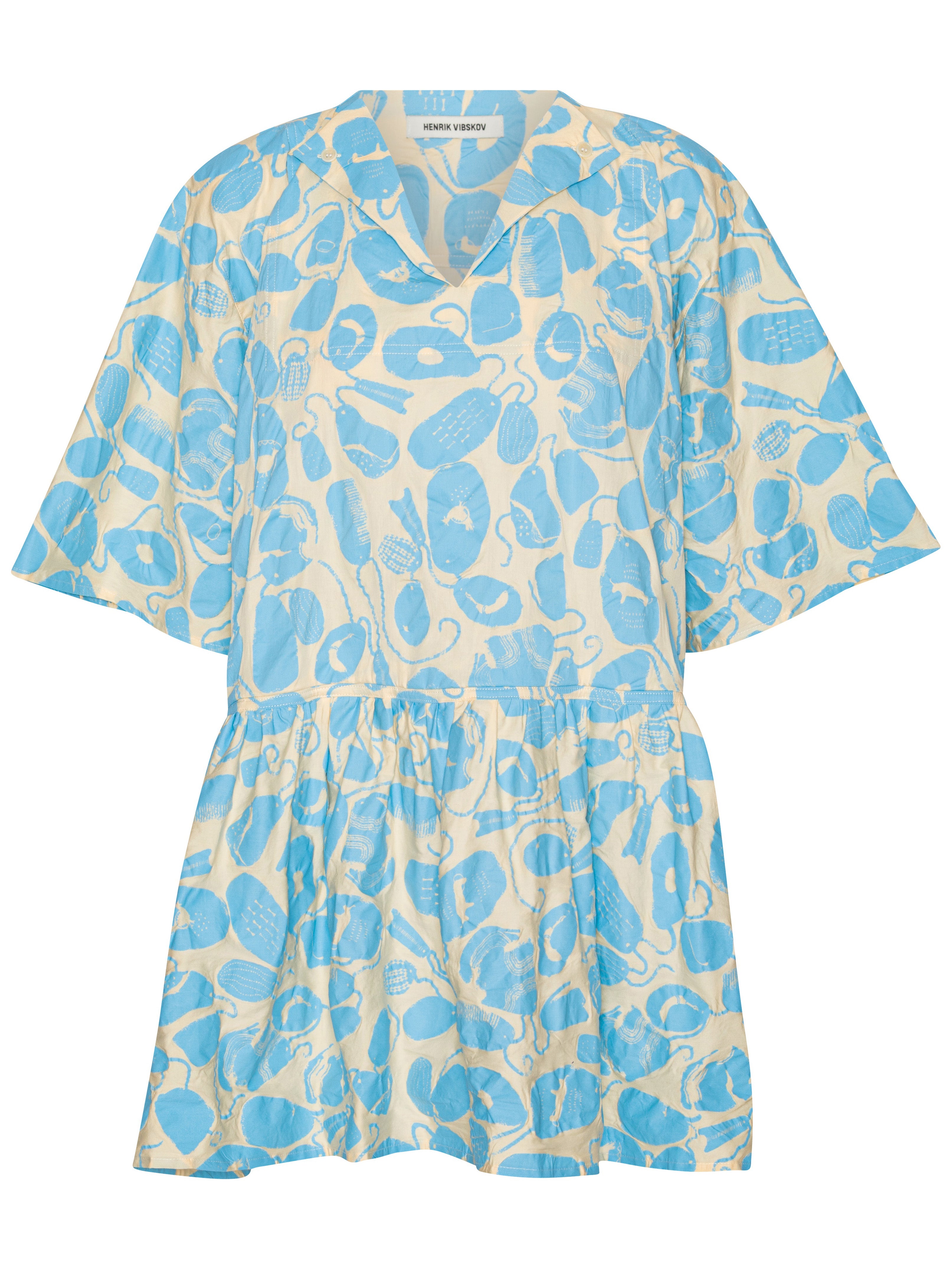 Front view of the Henrik Vibskov Preserve Blouse in Ecru Amulets, showing the off-white fabric with blue amulet pattern, V-neck with button, short sleeves, oversized silhouette, and wide, knee-length skirt.