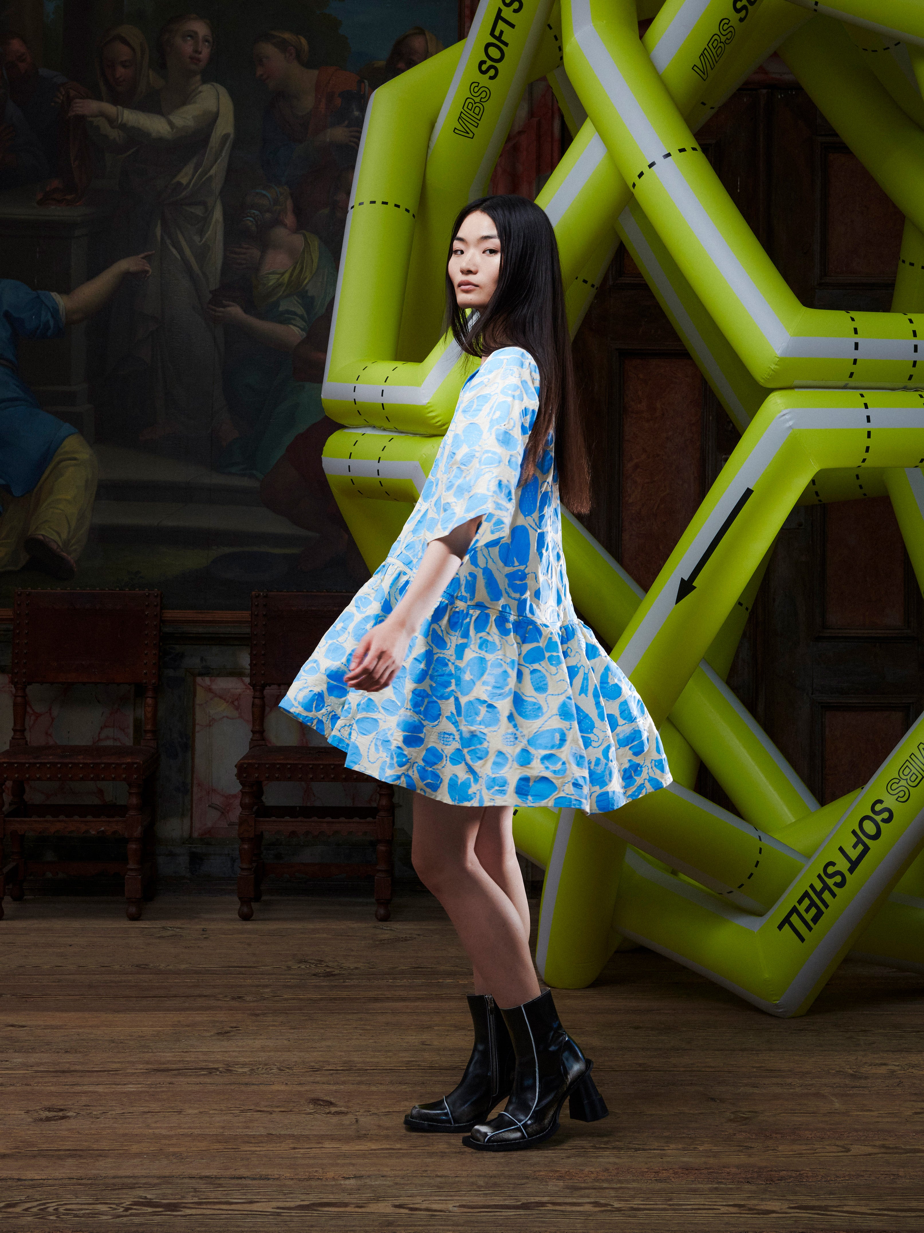 Model wearing the Henrik Vibskov Preserve Blouse in Ecru Amulets, side view, showing the volume of the oversized silhouette, short sleeves, and wide, knee-length skirt.