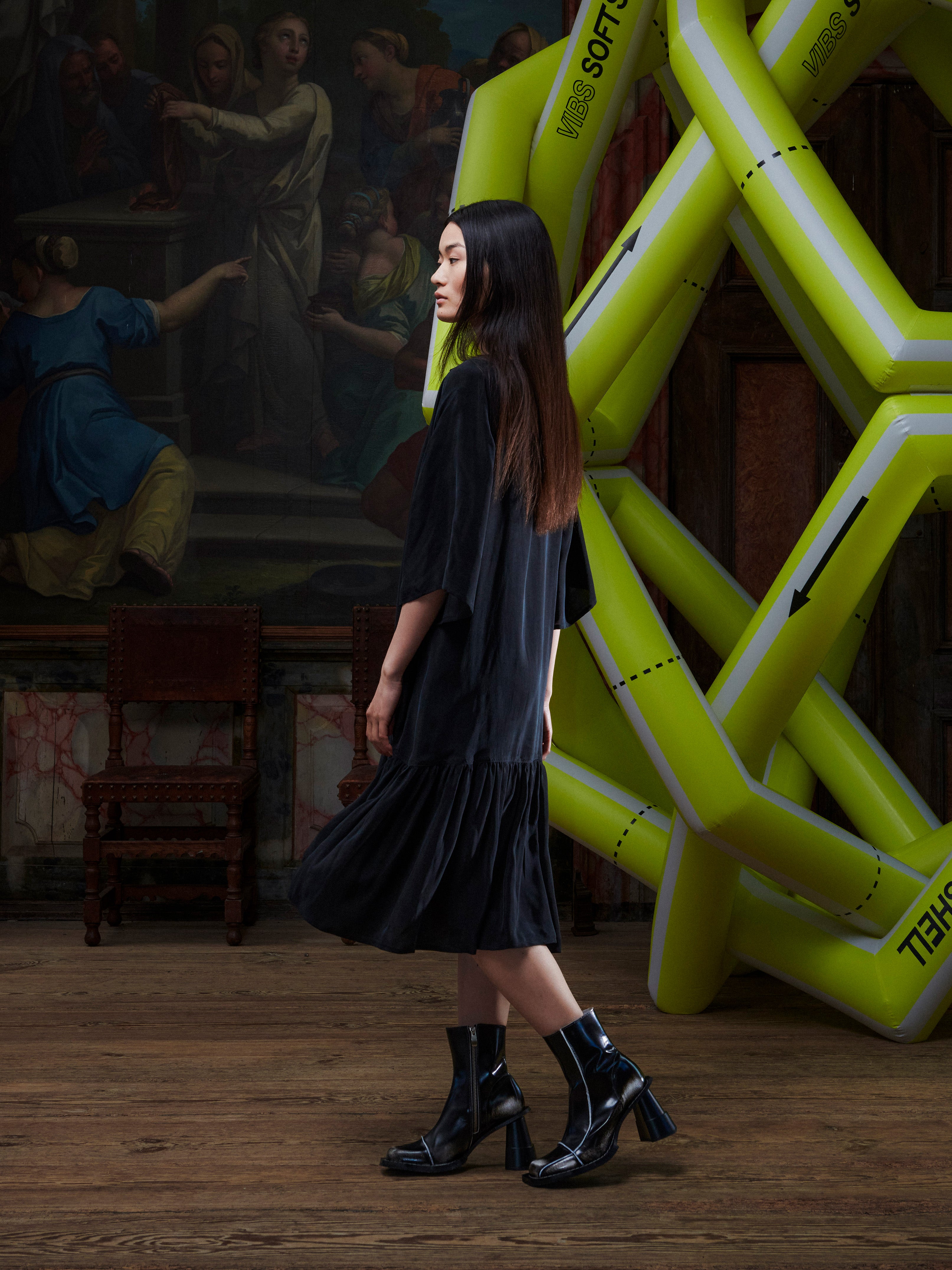 Model wearing the Henrik Vibskov Preserve Dress in black, side view, showing the relaxed shape, short sleeves, and straight hem.