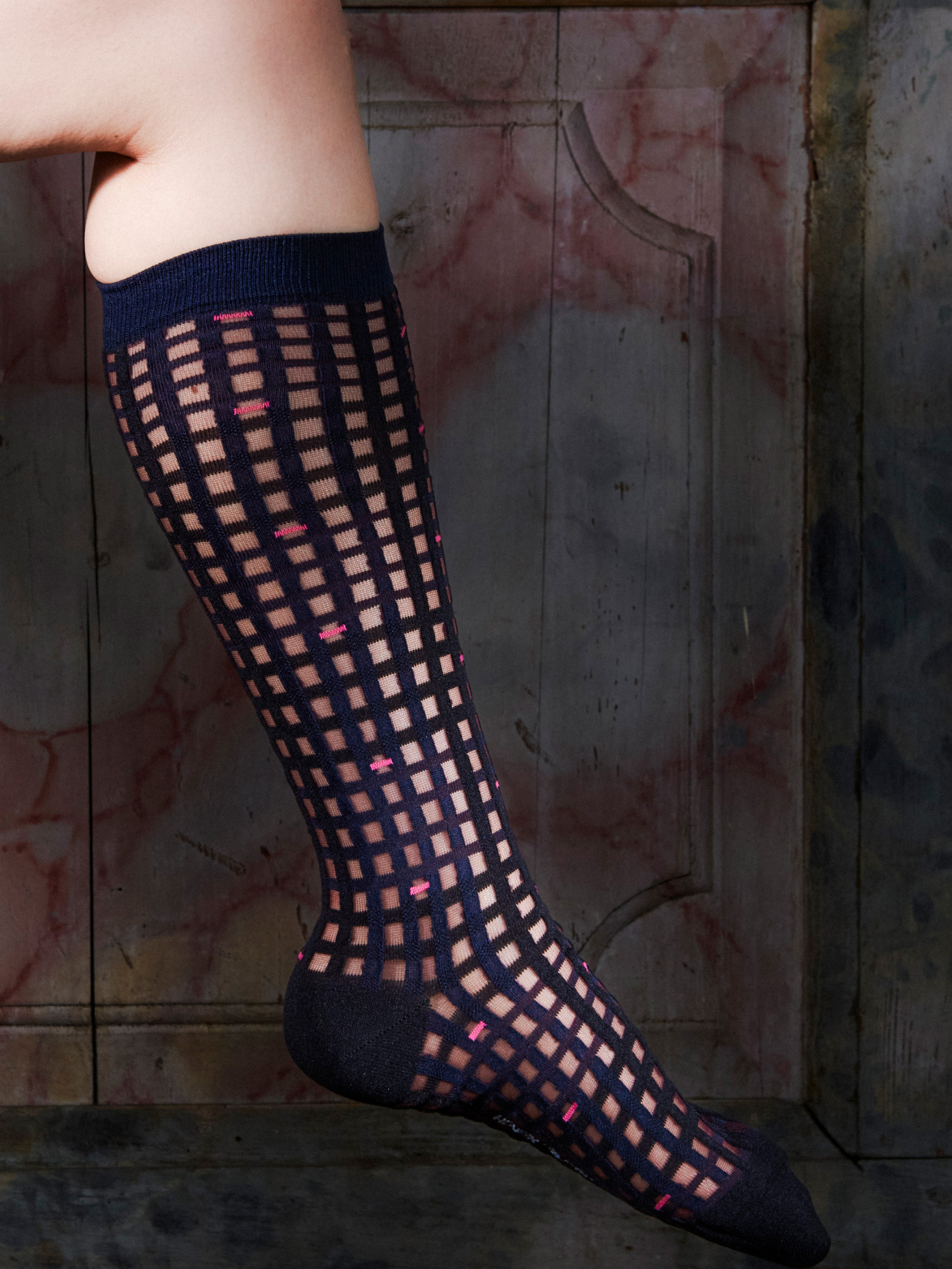Someone wearing the knee-length socks with a navy checkered pattern from Henrik Vibskov.