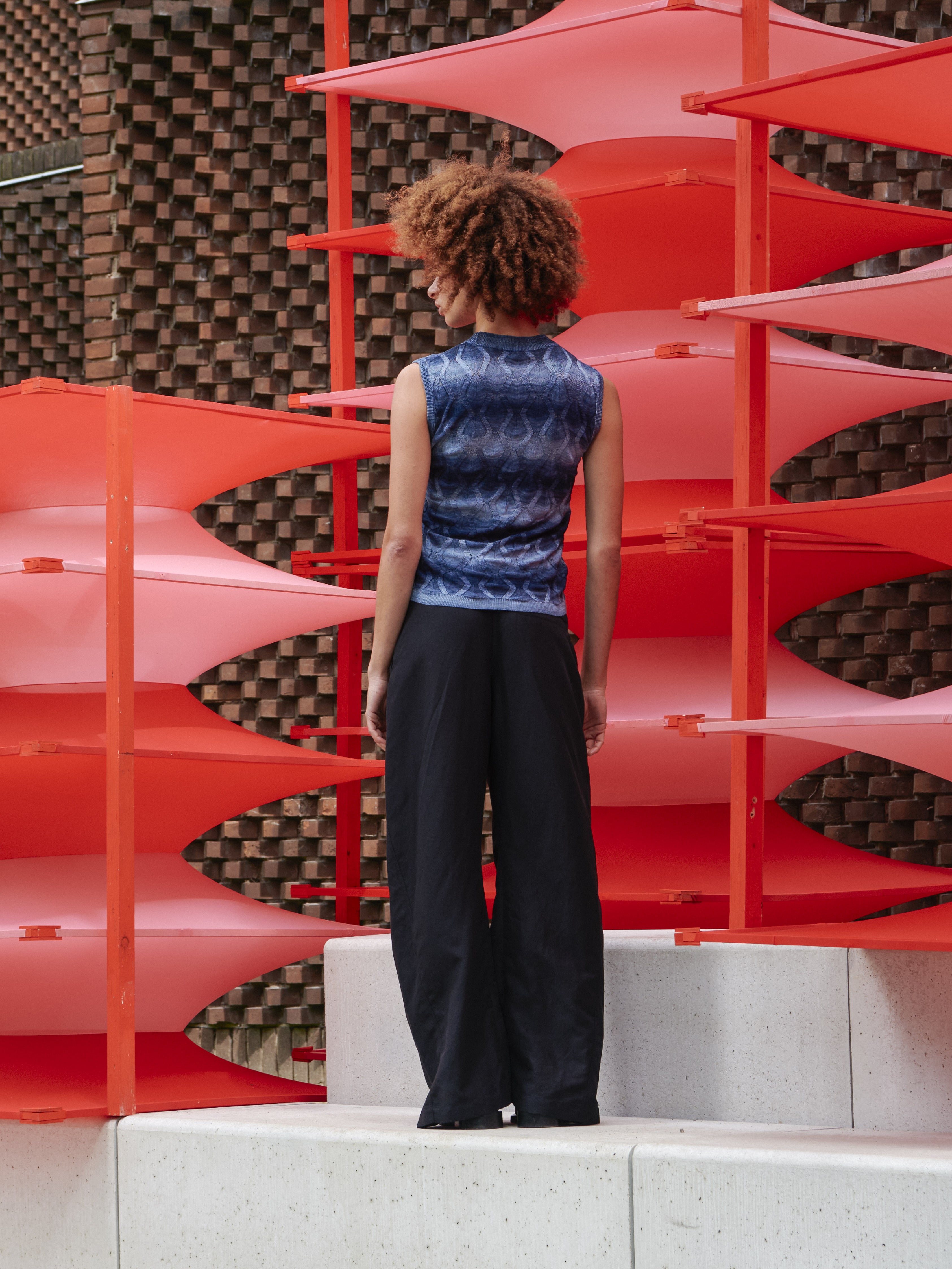 Model wearing the Resonance Top in Navy Flame blue patterned sleeveless top with ribbed hems and form-fitting silhouette, back view – Henrik Vibskov Spring/Summer 2026 Key Collection