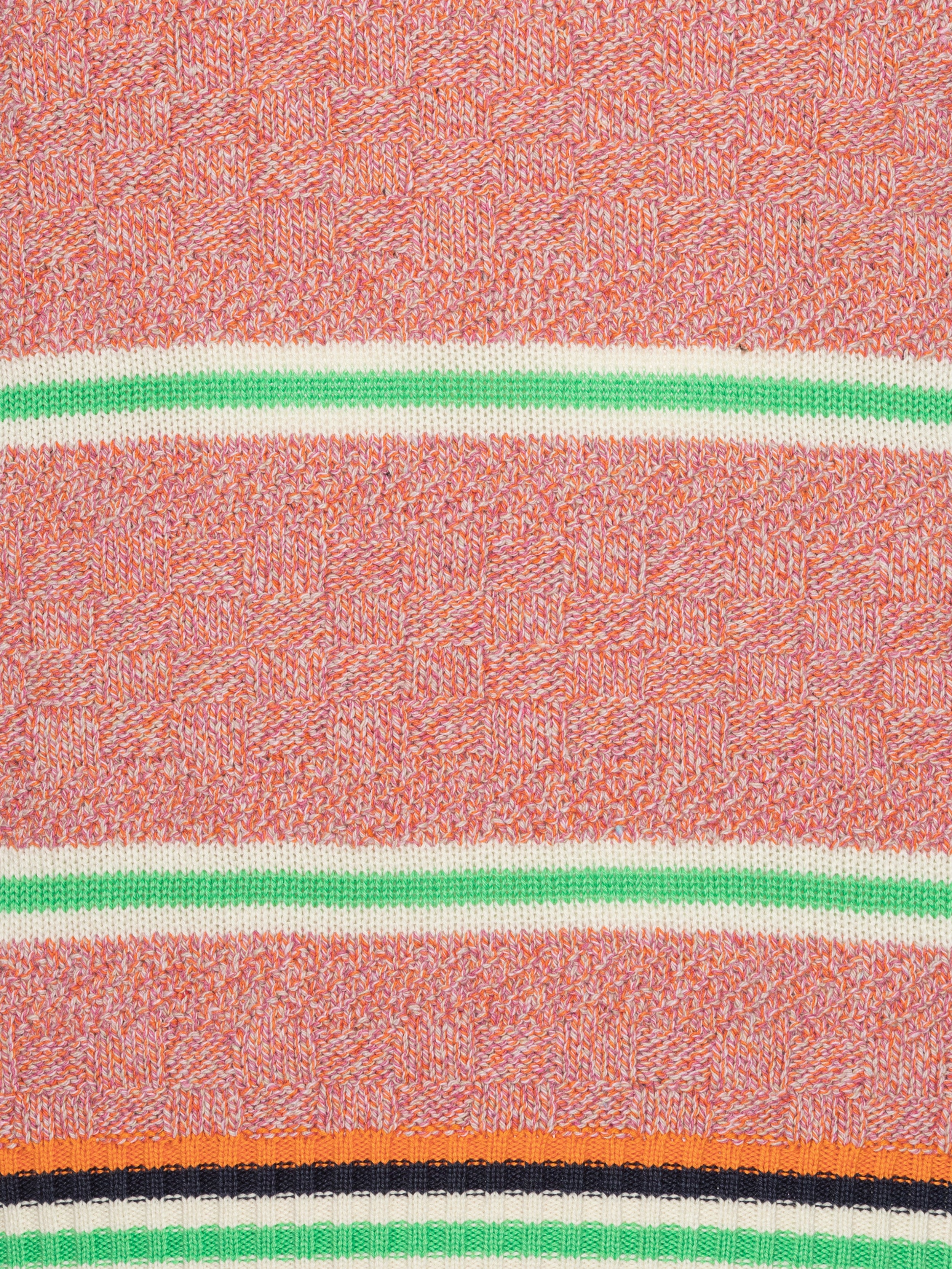 Close-up of pink-orange knitted top with stripe details from Henrik Vibskov