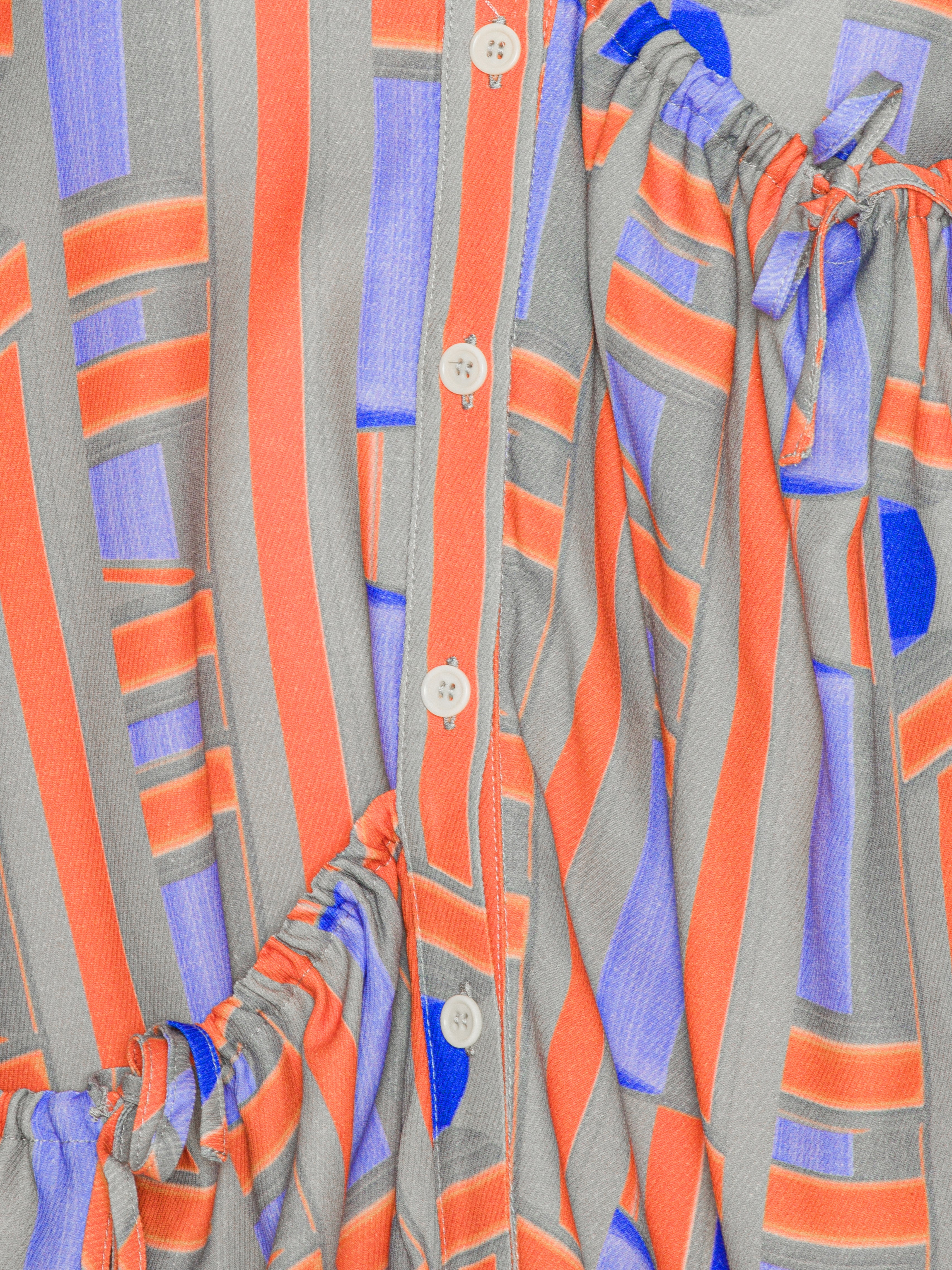 Close-up of a patterned fabric with orange, gray, and blue stripes.