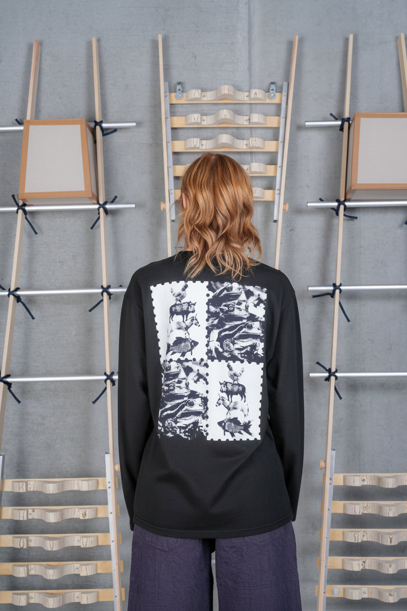 Back view of a female model wearing the Henrik Vibskov Tower Swamp Blouse in Black, highlighting the large off-white graphic print across the back and relaxed silhouette.