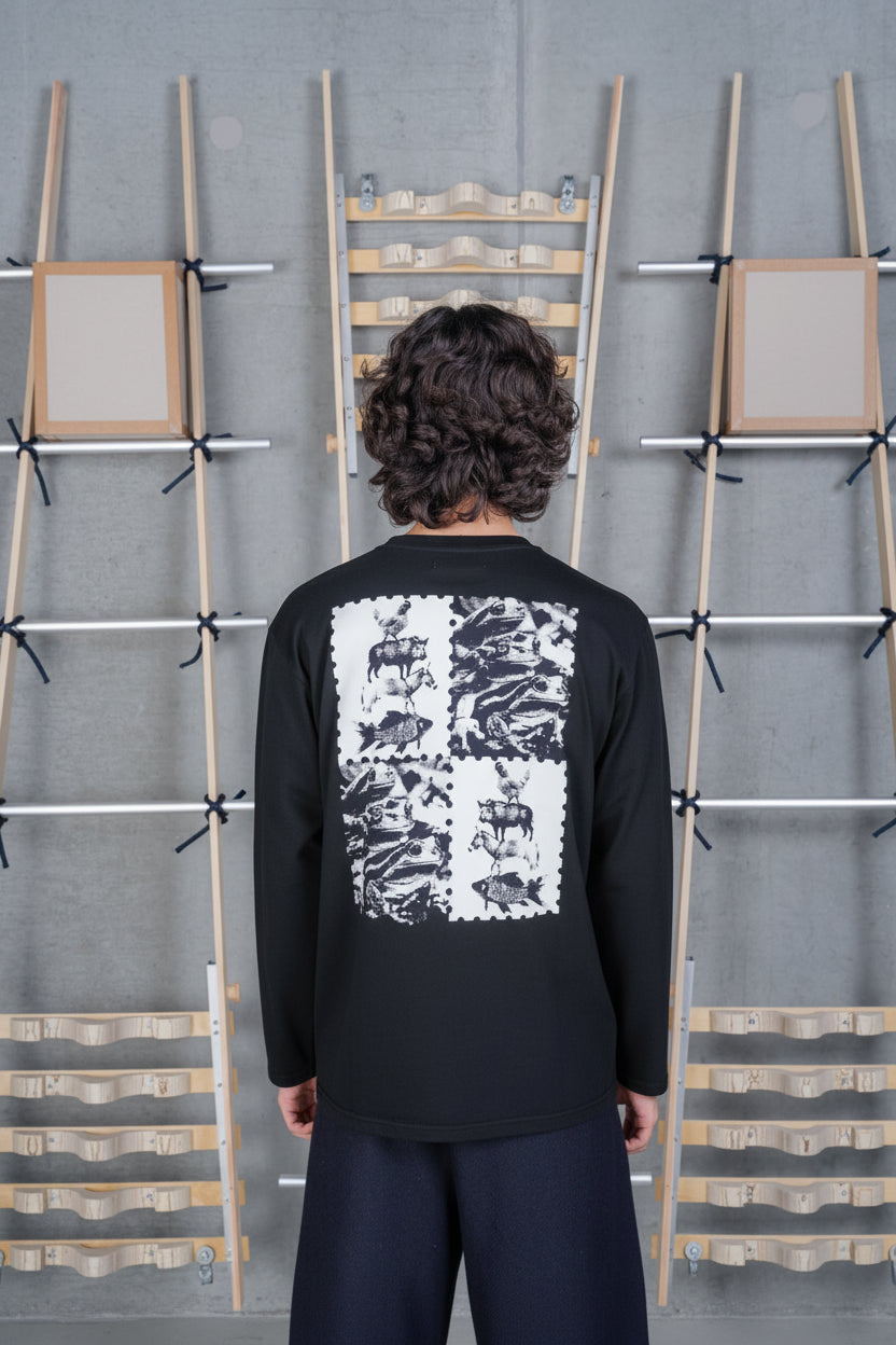 Back view of a male model wearing the Henrik Vibskov Tower Swamp Blouse in Black, featuring the bold back graphic print and easy-fitting crew neck silhouette.