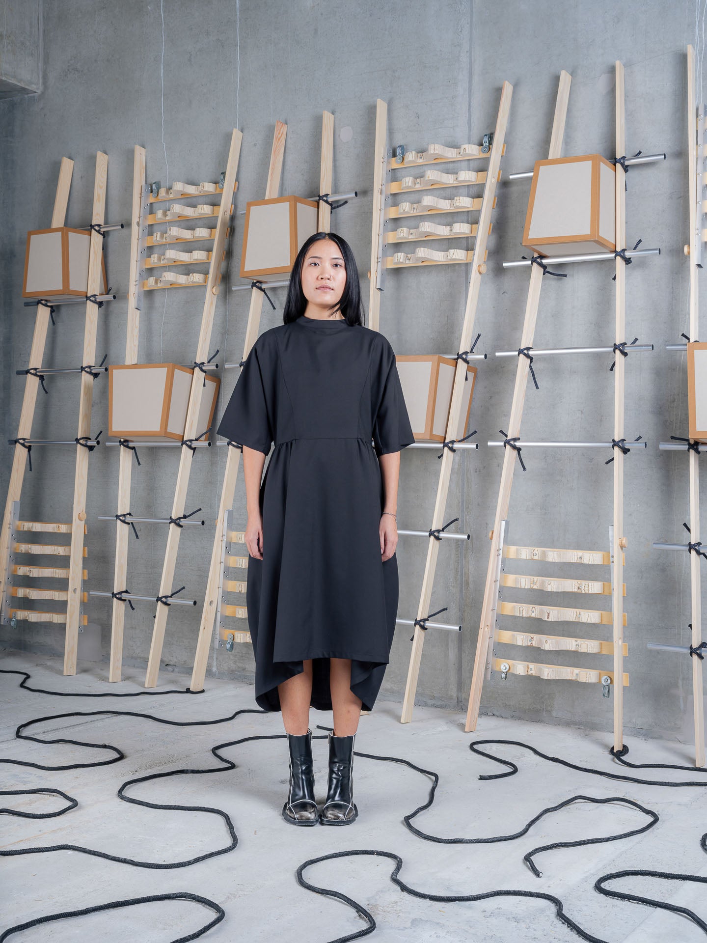 Model wearing Henrik Vibskov Very Turtle Dress in tropical black with relaxed turtleneck collar and voluminous draped silhouette