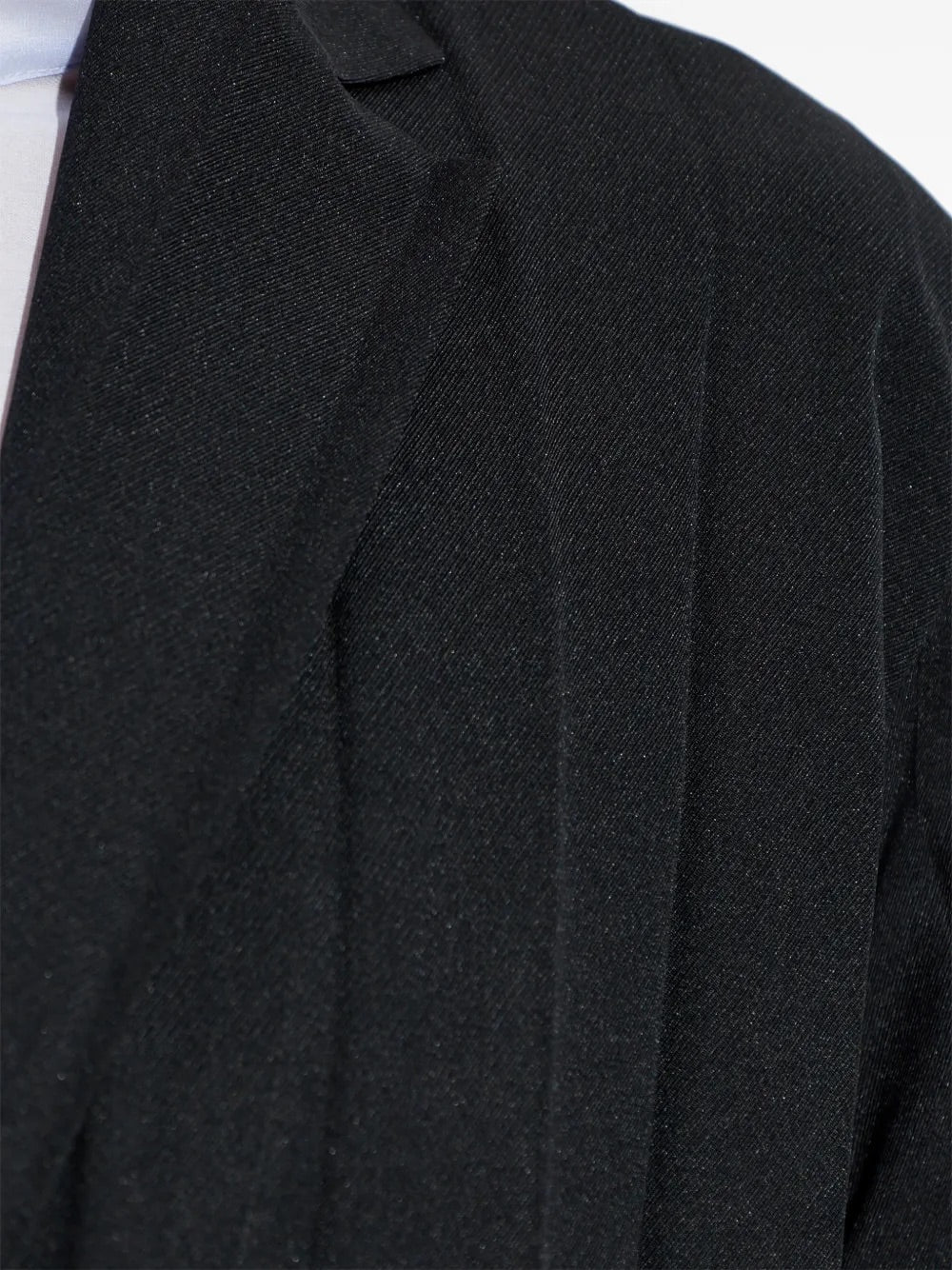 Edge Ensemble Jacket in Black by Homme Plissé Issey Miyake, closeup of large plissé texture and button detail on black blazer
