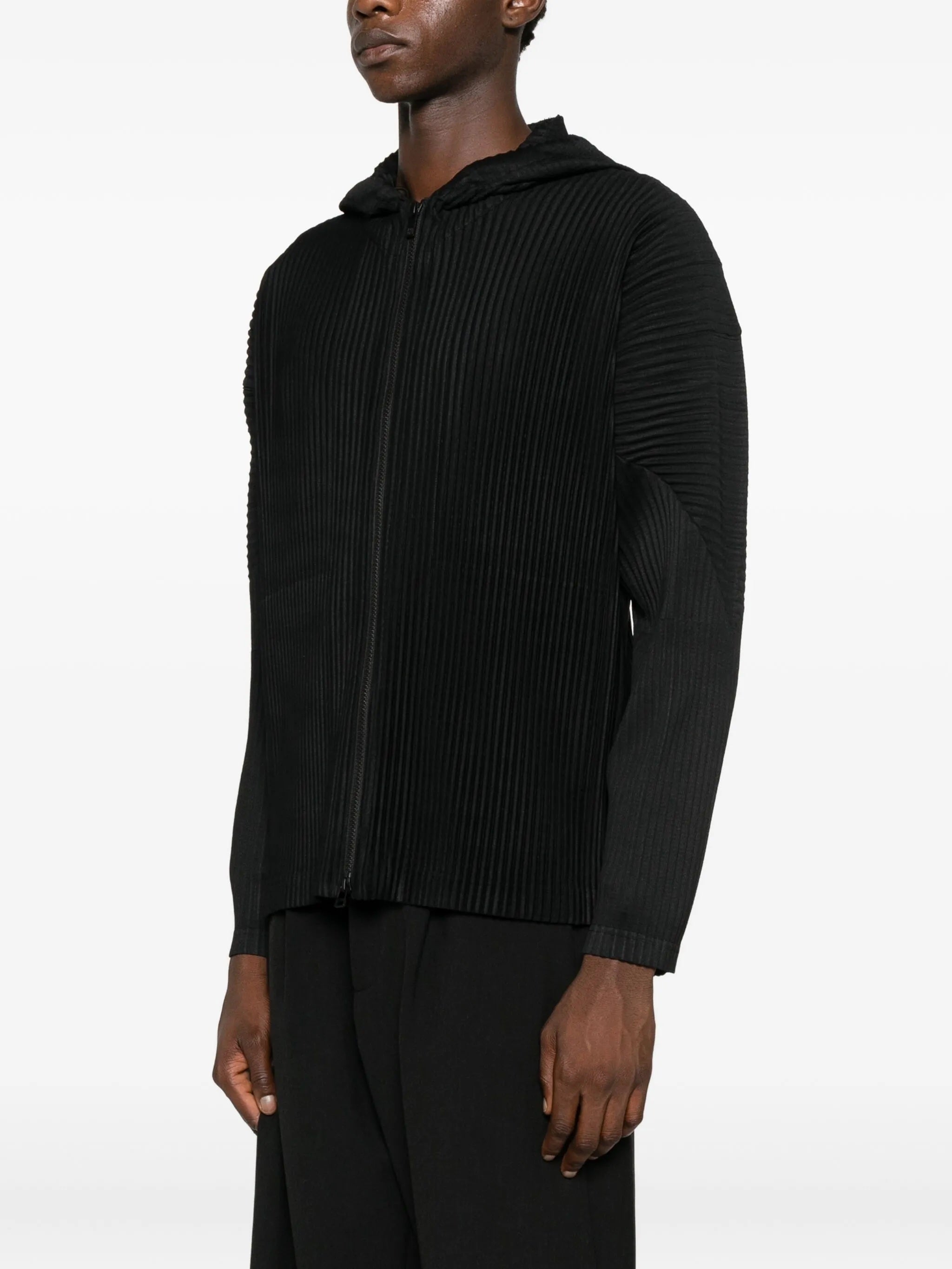 Person wearing a black ribbed hoodie on a white background