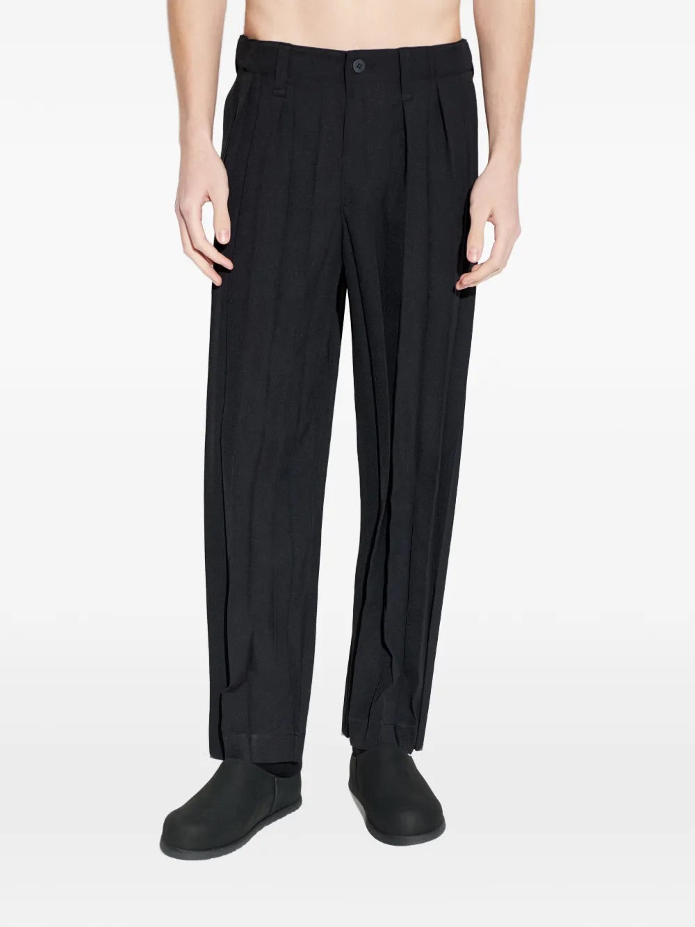 Model wearing Edge Ensemble Pants in Black by Homme Plissé Issey Miyake, front closeup of large plissé pleating and belt loops on slim-leg black trousers
