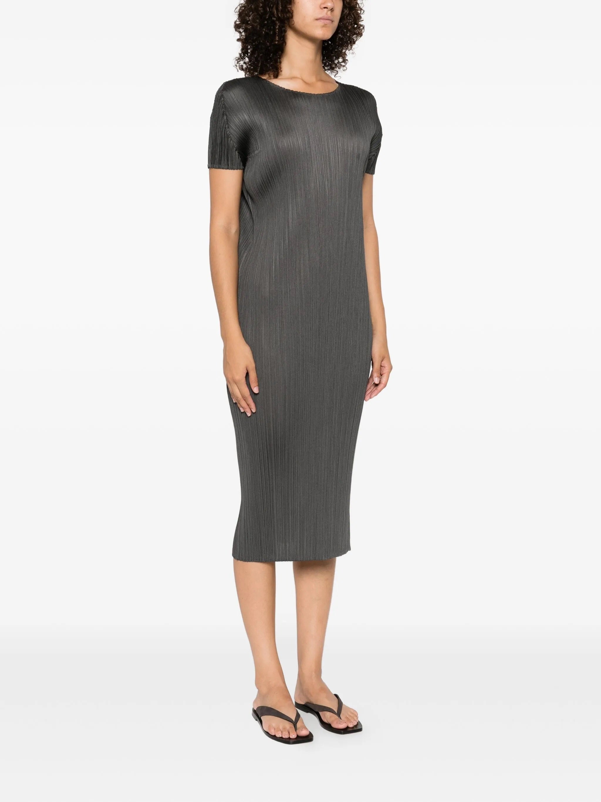 Woman wearing a gray pleated dress on a white background