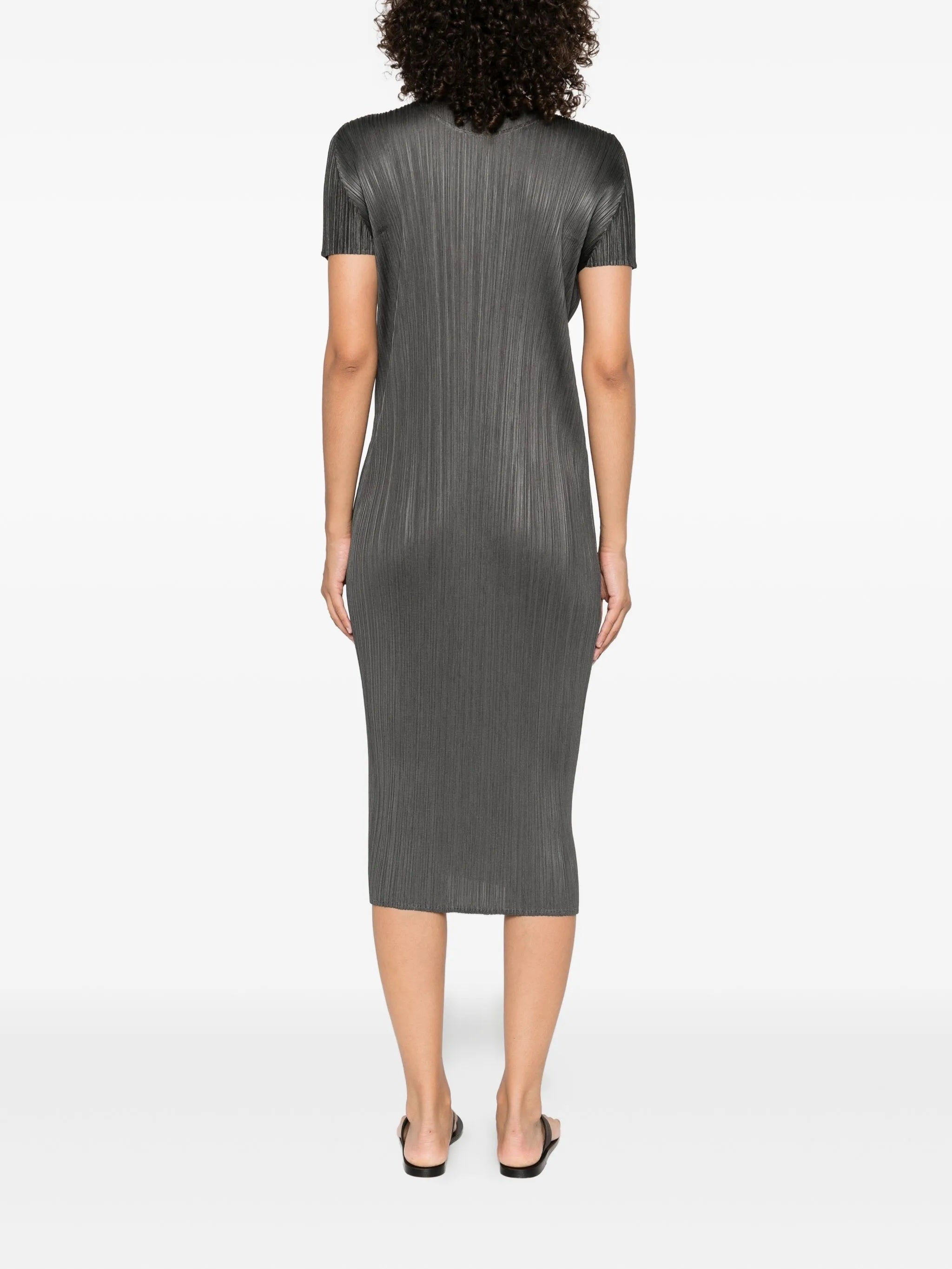 Woman wearing a gray pleated dress on a white background