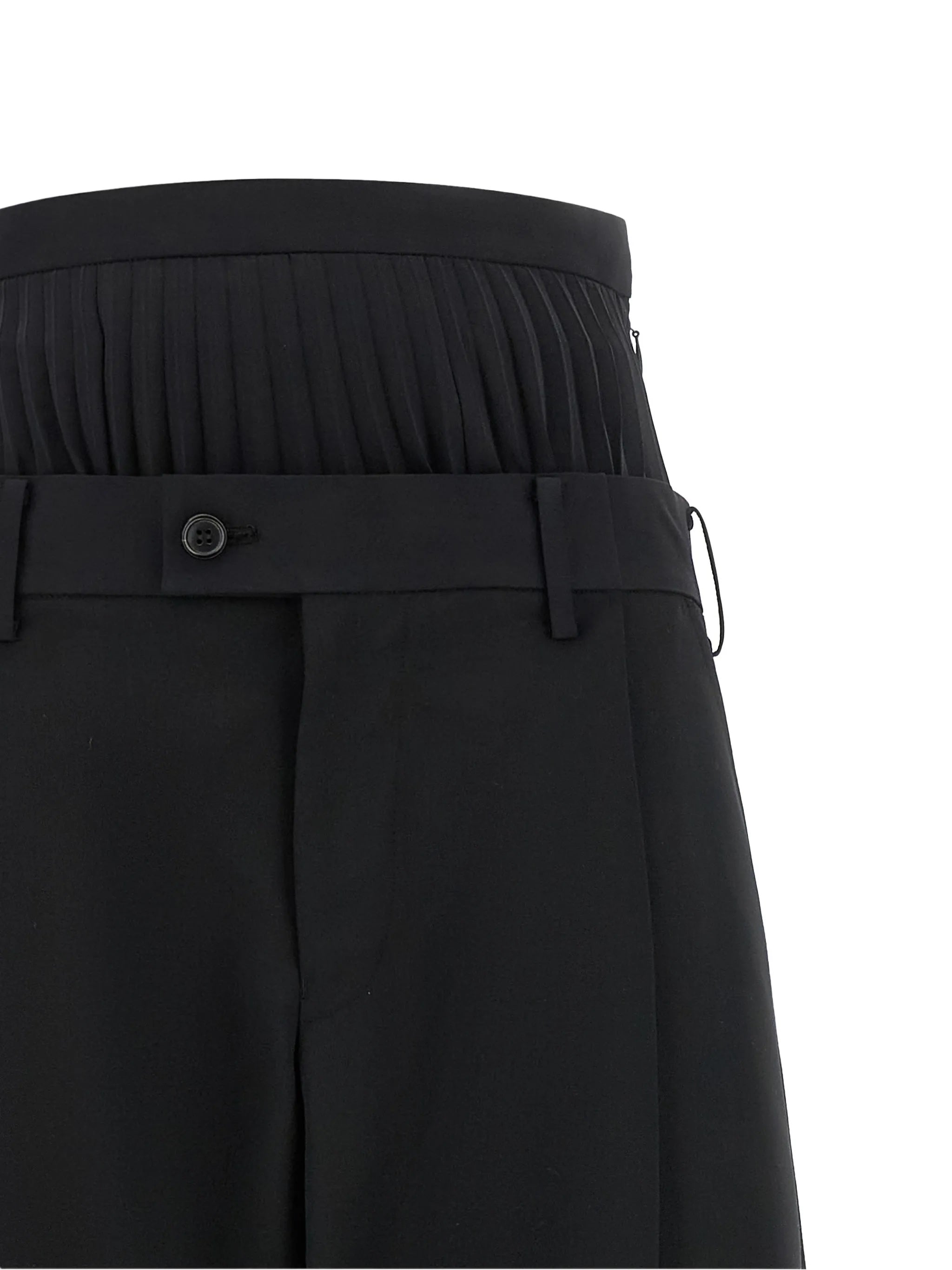 Junya Watanabe Women's Layered Half-Pleated Trousers in black, close-up of layered waist construction, pleated band over tailored waistband with button fastening