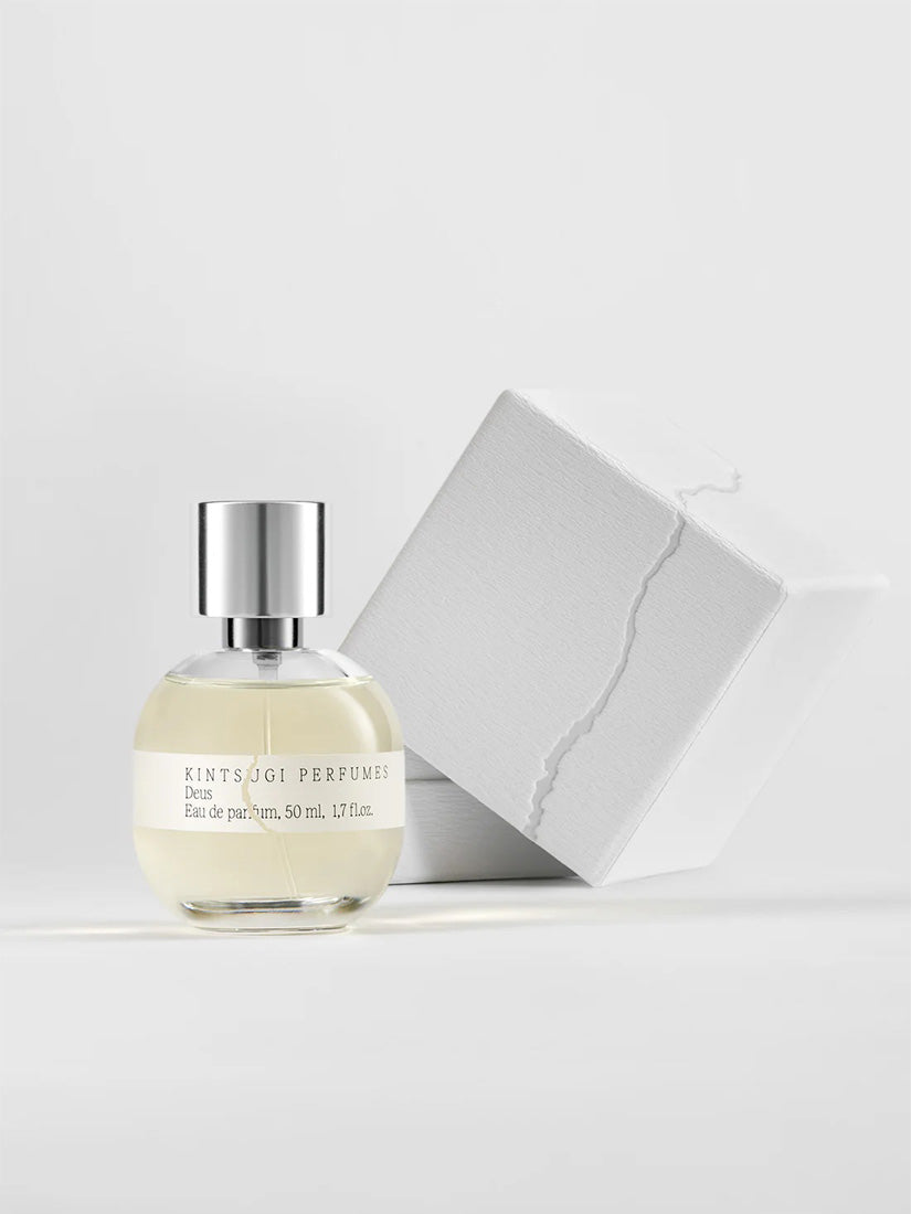 Perfume bottle with its white box packaging on a light background