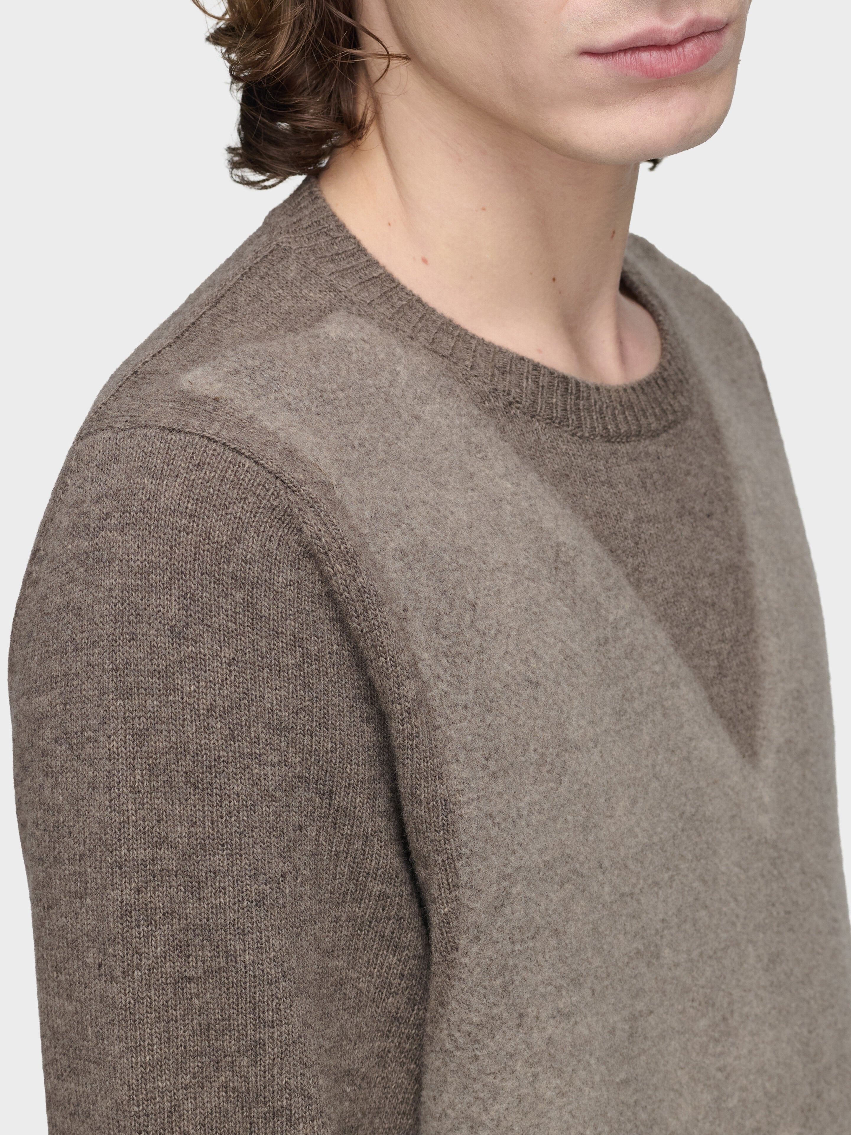 Maison Margiela Fused Knit Sweater in Mud Ecru, close-up of trompe l'oeil V-neck and crew neck detail, needle-punched panel, mud ground lambswool