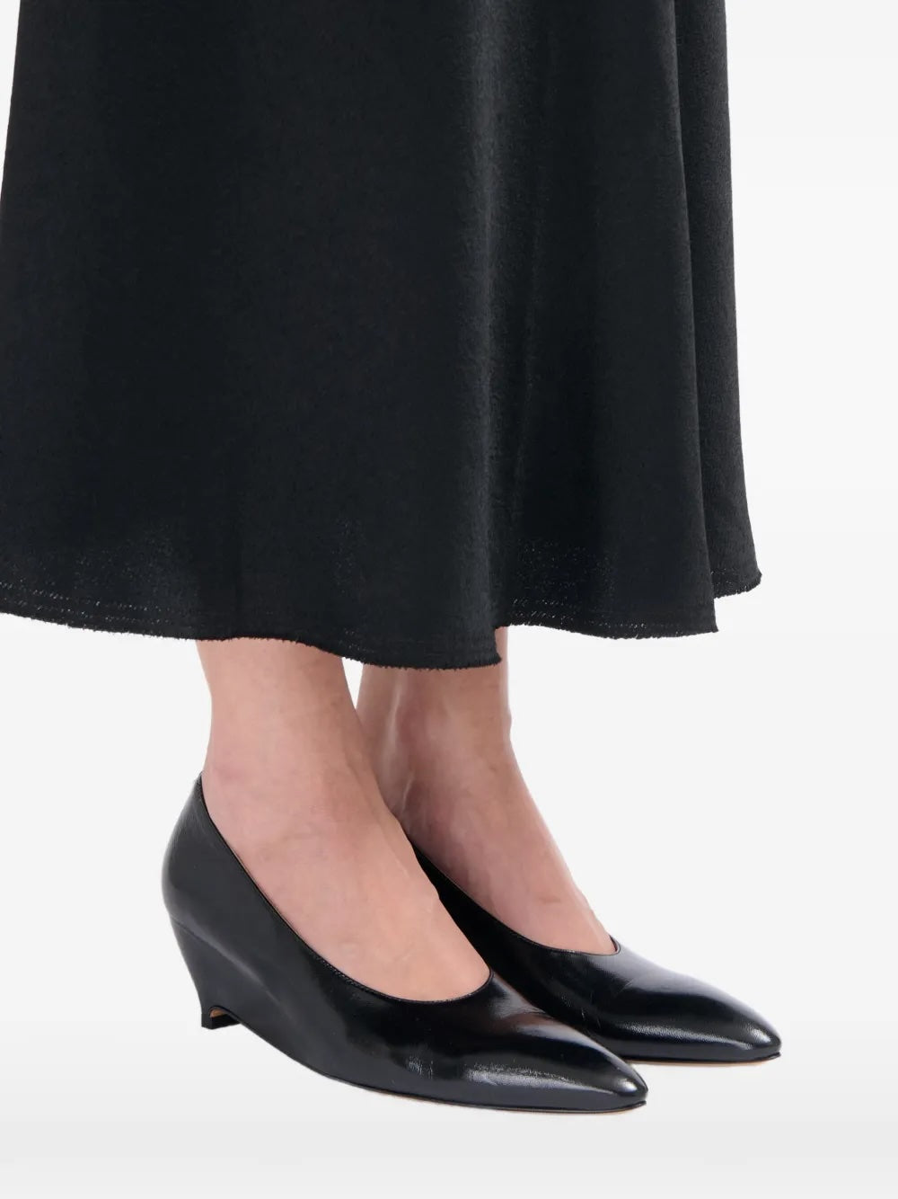 Maison Margiela Heel-Less Pump 55mm worn with a black midi skirt, styled on model to show low wedge height and elegant pointed silhouette
