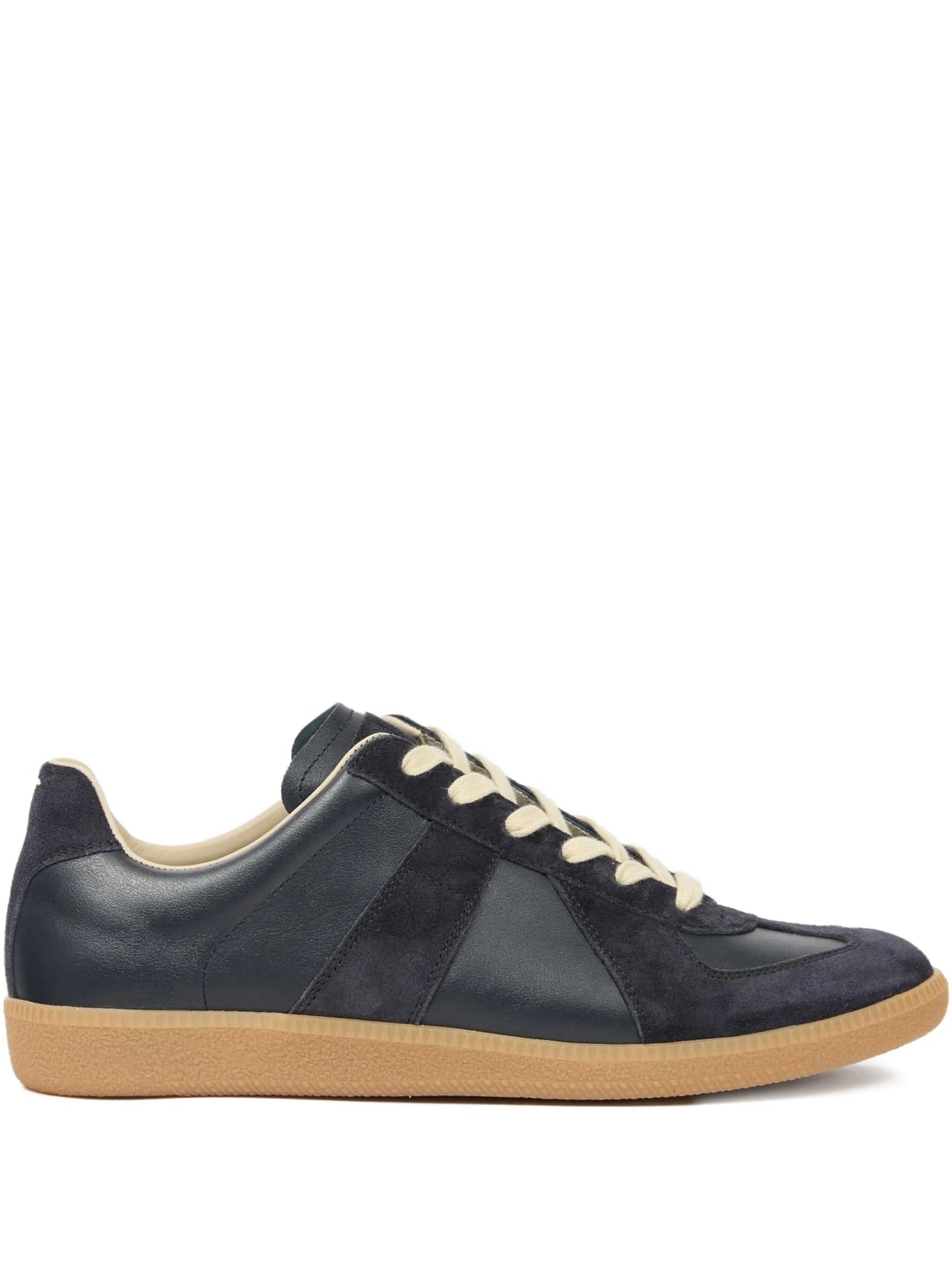 Dark navy blue leather sneakers with panel design and rubber soles on a white background