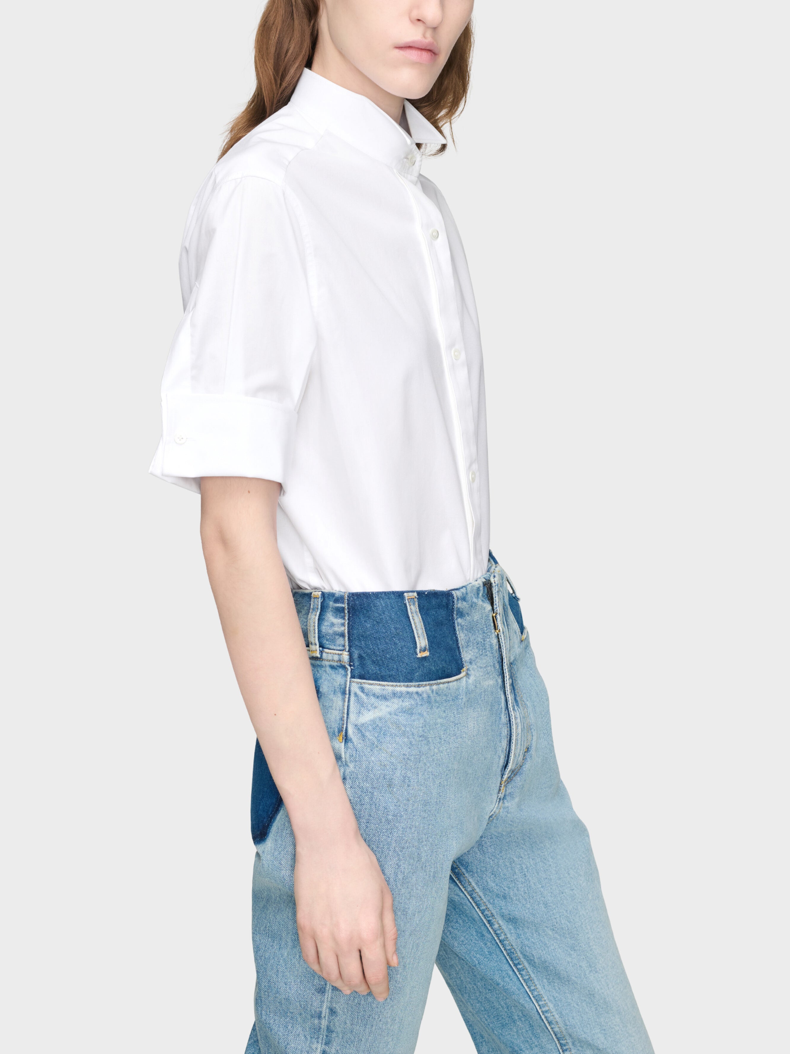 Maison Margiela Snapped Button Short Sleeves Shirt in White on-model side view, elongated hem, relaxed oversized silhouette, turn-back cuffs