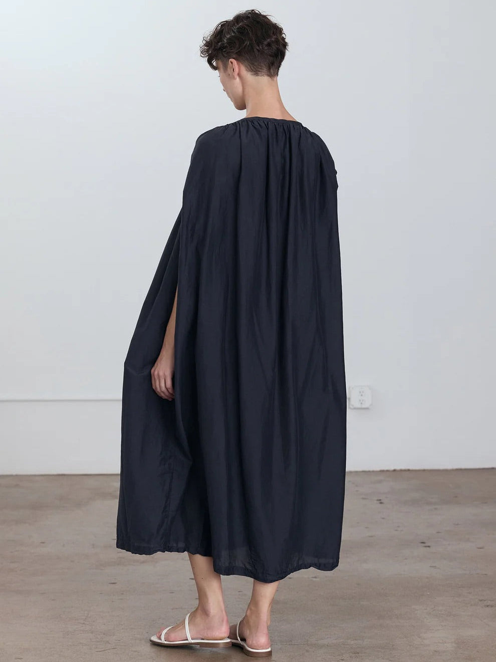 Black Crane Mont Blanc Dress in Faded Black - three-quarter view on model showing oversized silhouette and silk cotton blend fabric
