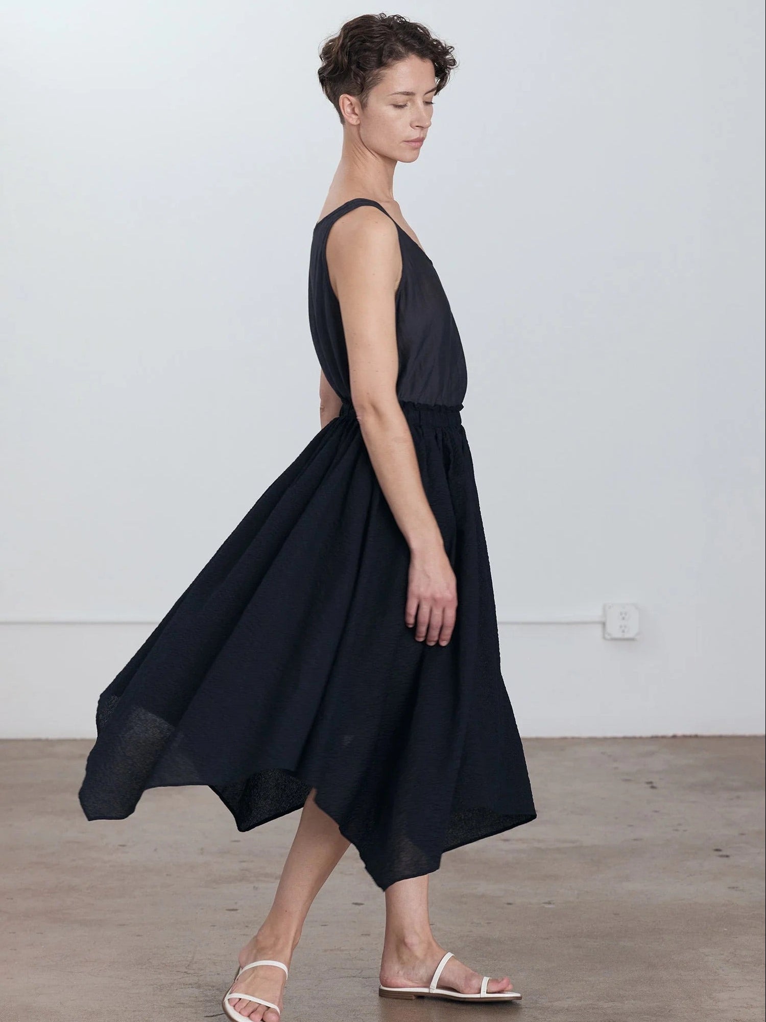 Black Crane Paper Skirt in Midnight - side view on model showing voluminous four-panel silhouette and asymmetric hem