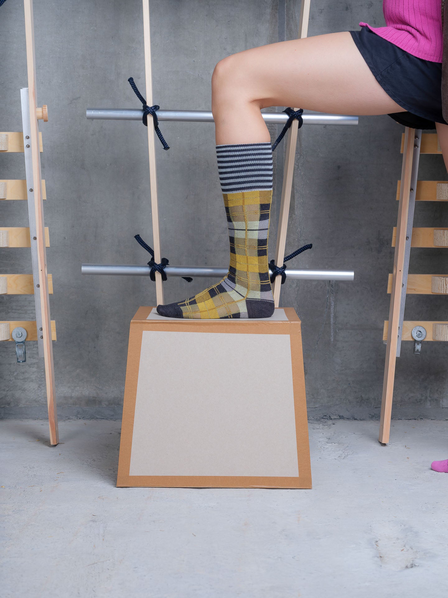 Model wearing Ribbit Knee Sock in Grey Black Dashed Checks by Henrik Vibskov