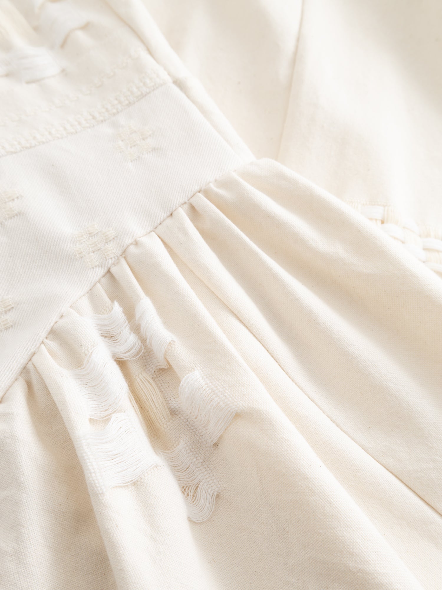 Stem Patchwork Dress in off-white, close-up of gathered skirt and zero-waste patchwork fabric construction detail